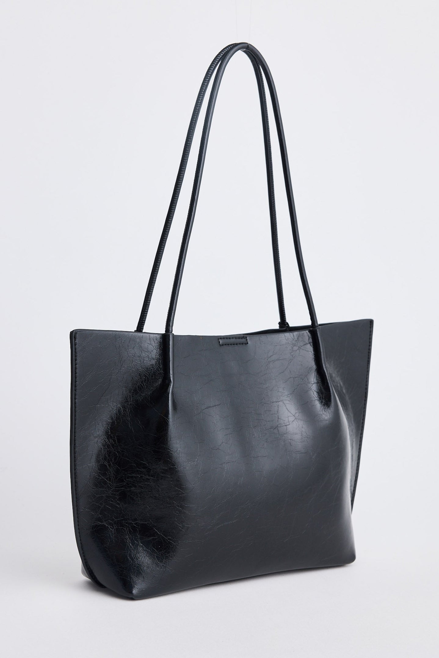 Black leather tote bag on a light gray background
