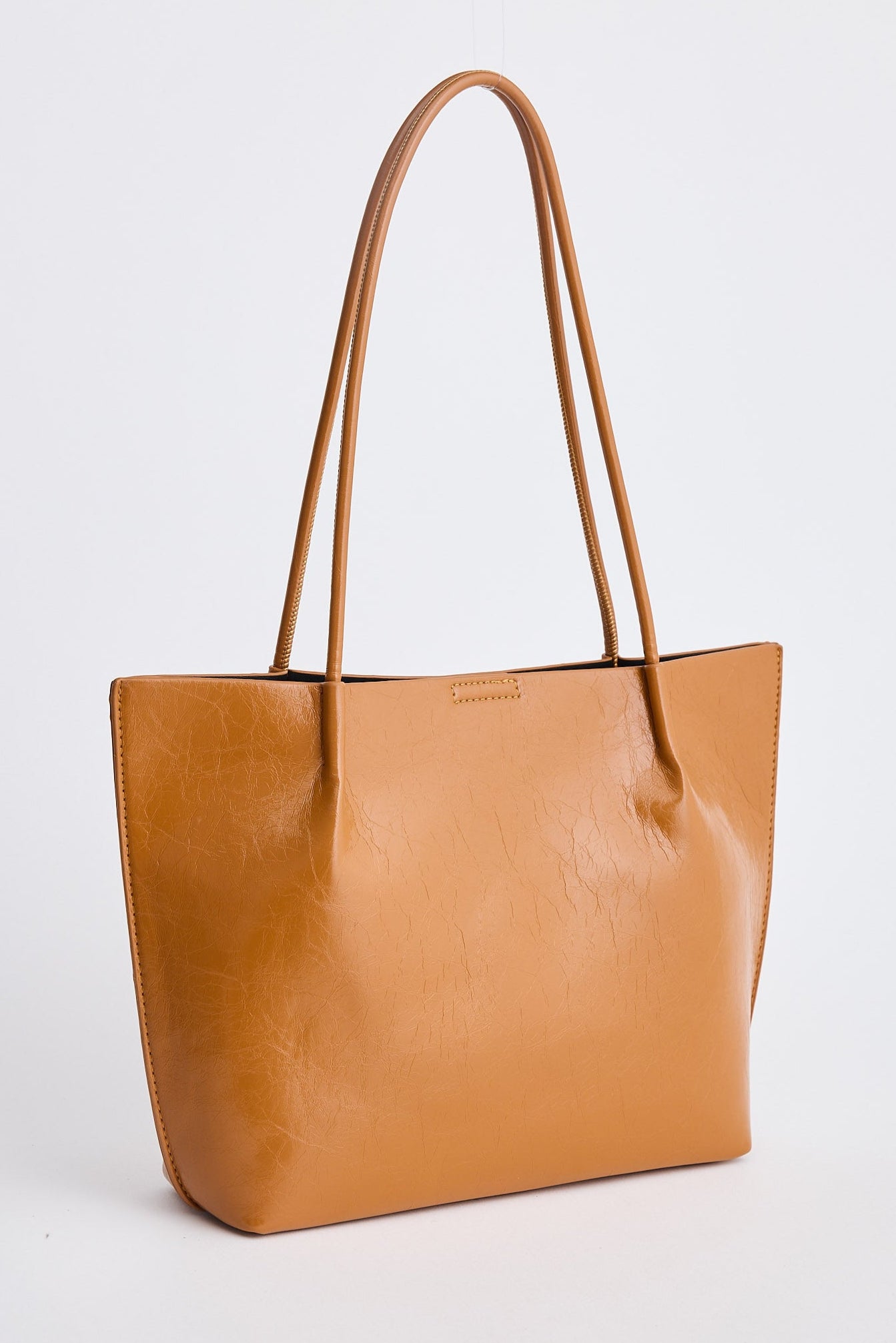 Tan leather tote bag on a light gray background