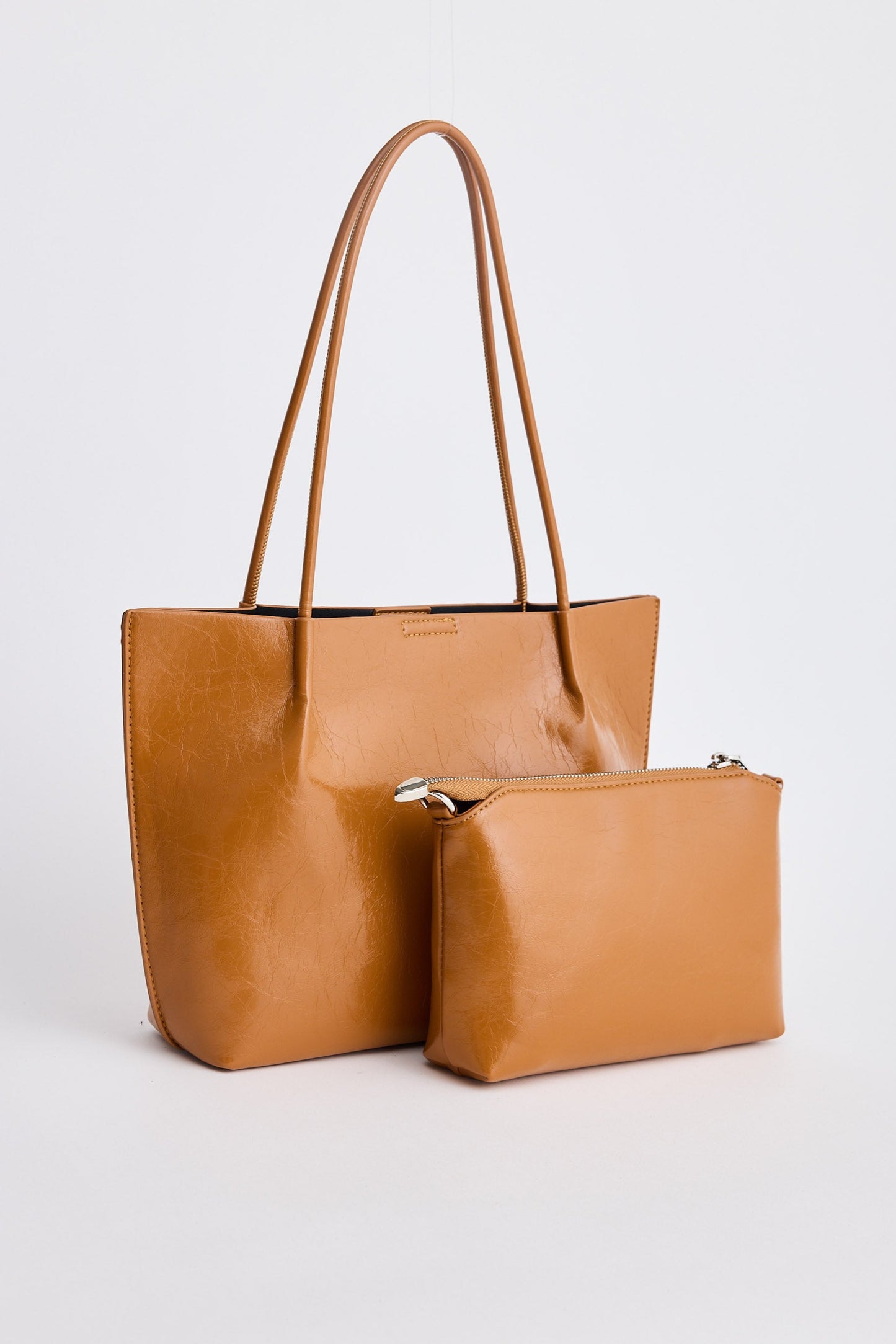 Tan leather tote bag and matching pouch on a white background