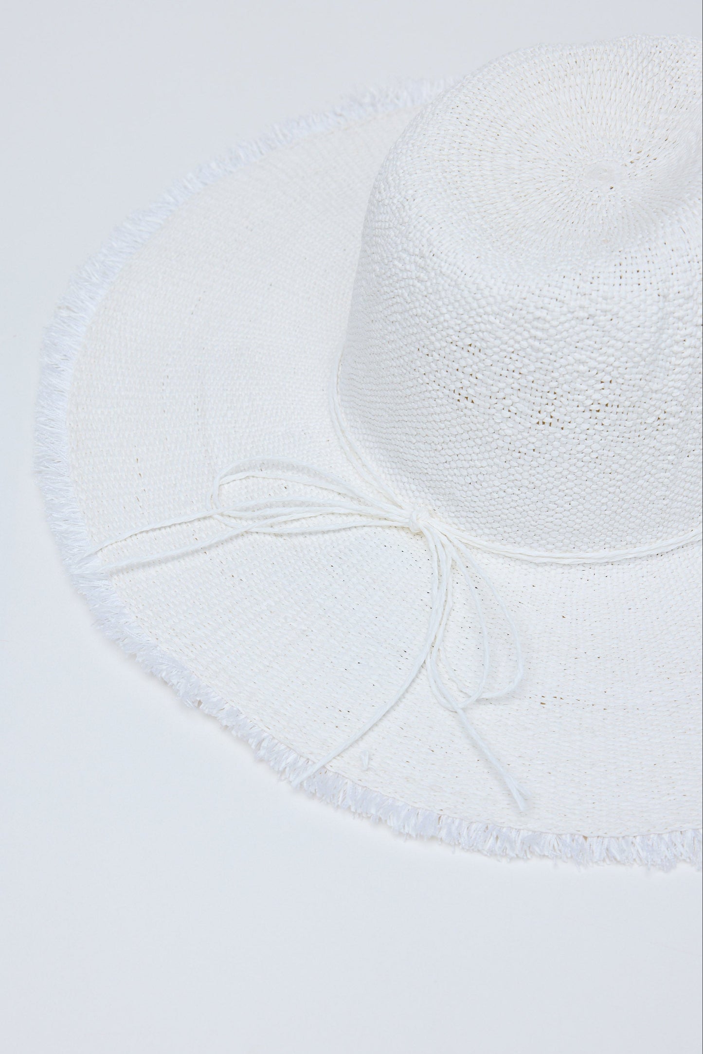 Close-up of a textured white hat on a light gray background
