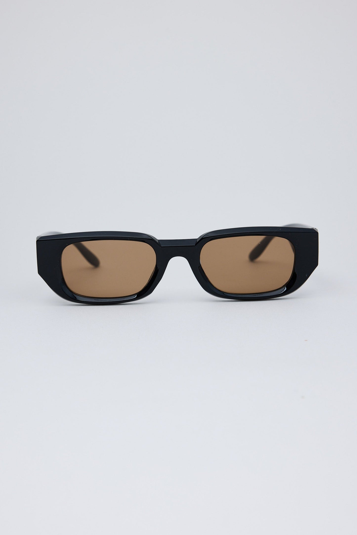 Black sunglasses with brown lenses on a white background