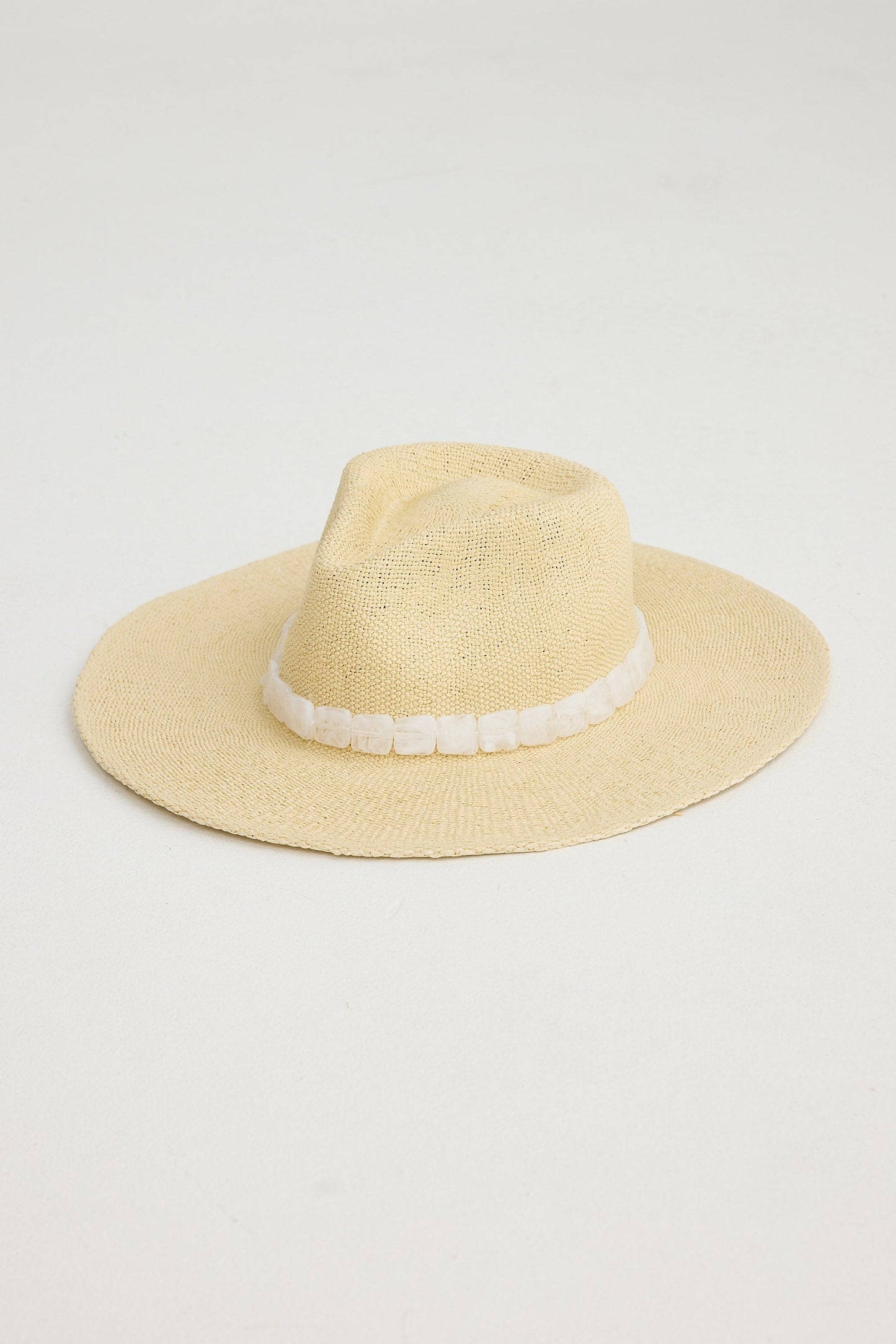 Natural straw hat with a white band on a light gray background