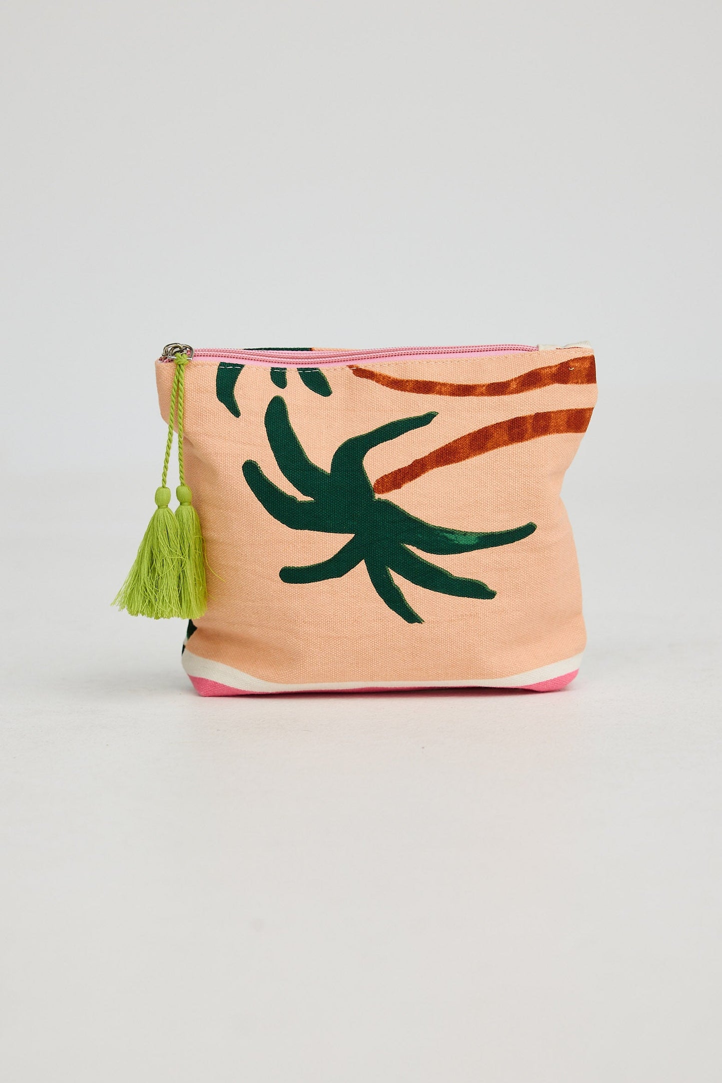 Small pouch with palm leaf design and tassel on a light gray background