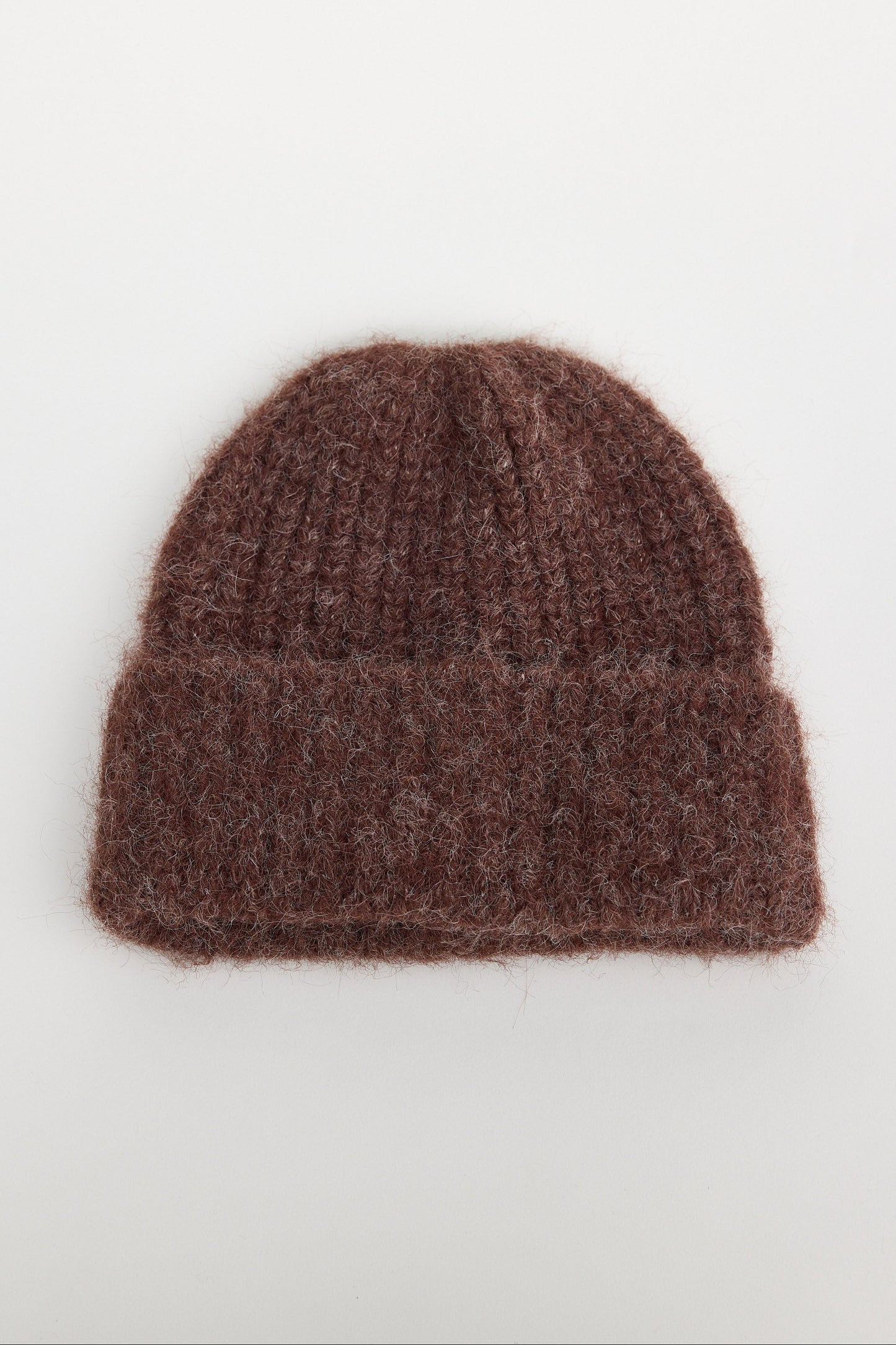 Brown knit beanie on a white background