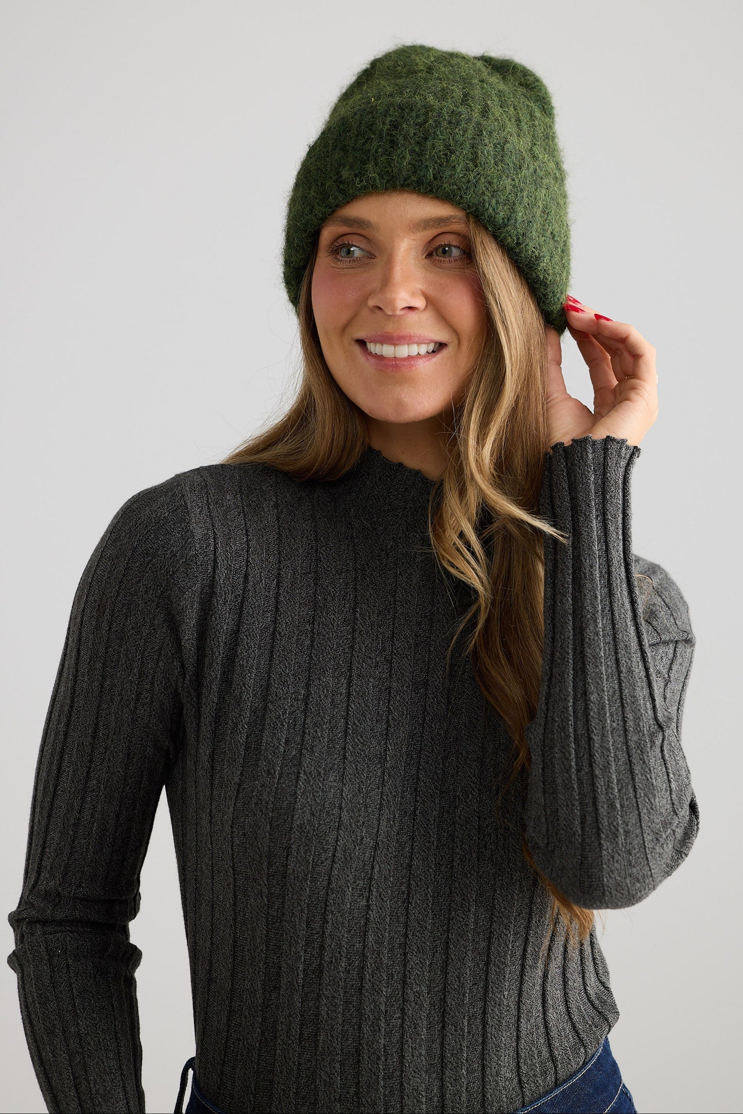 Model wearing Andrea Beanie - Olive beanie in olive with wide rib texture, styled on model view on white background