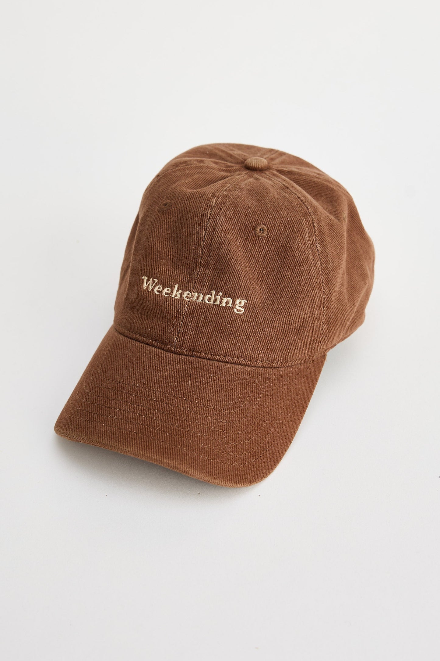 Brown cap with 'Weekending' text on a white background