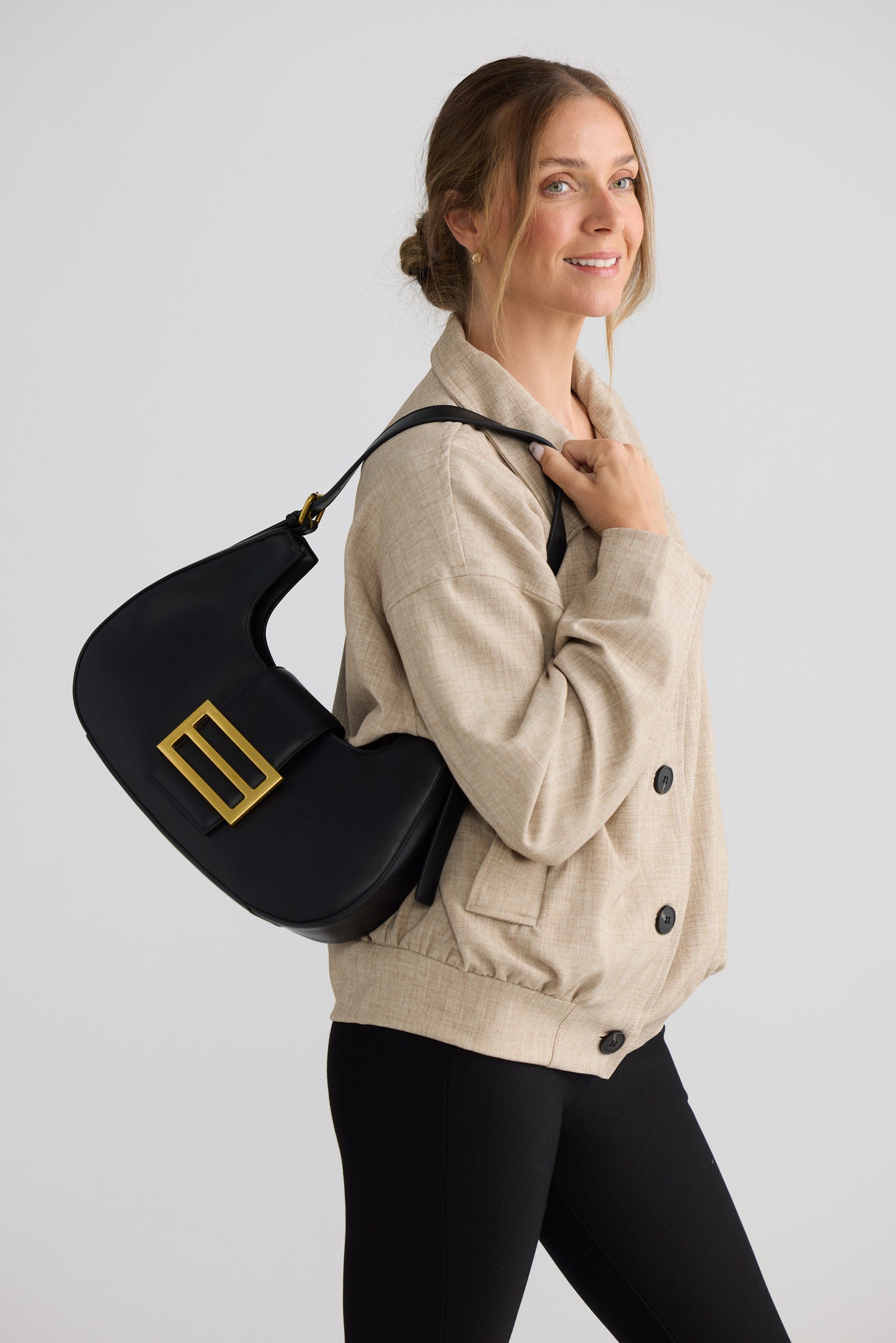 Virginia Handbag - Black handbag in black with gold-tone hardware, detail view on white background