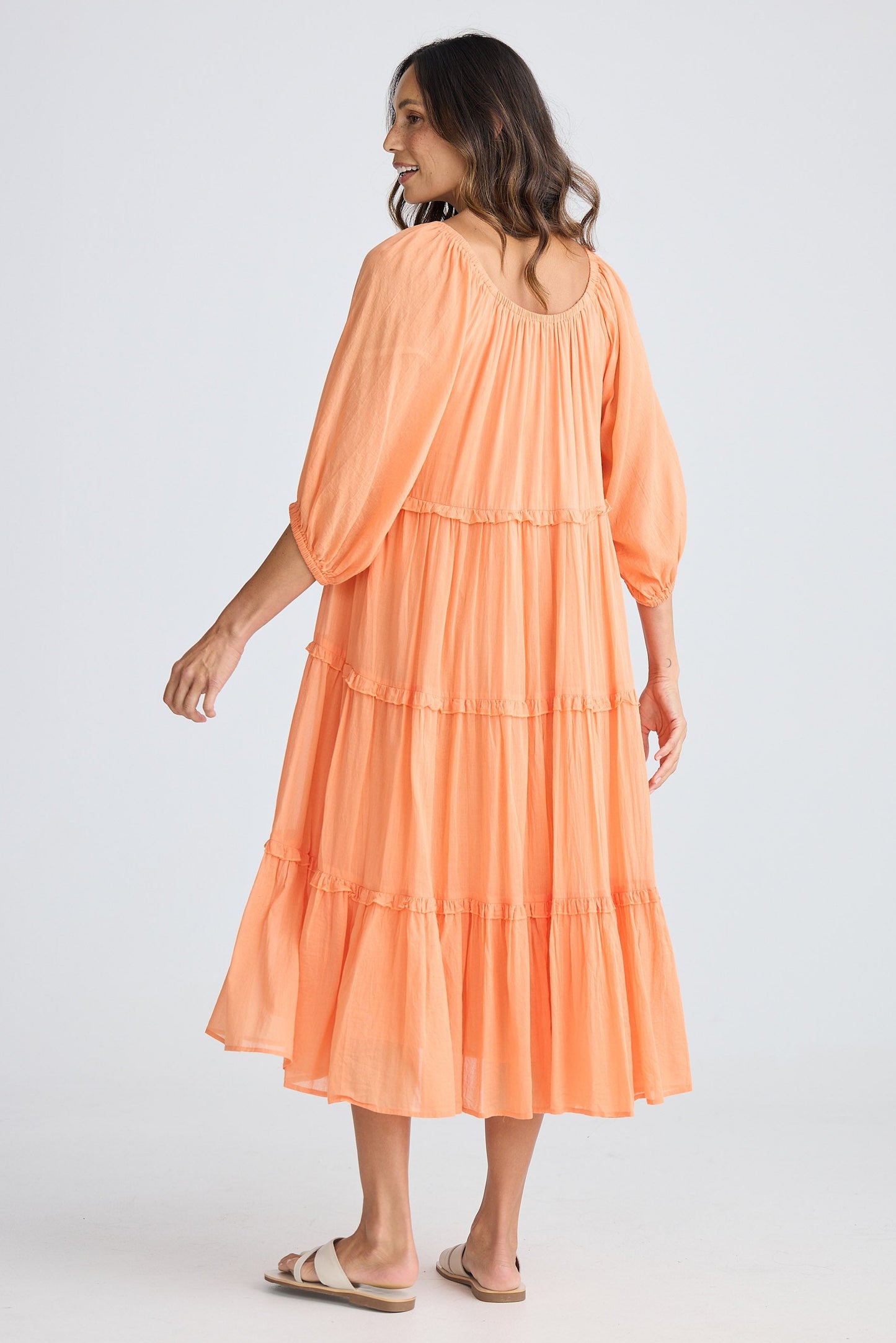 Woman wearing an orange dress on a white background