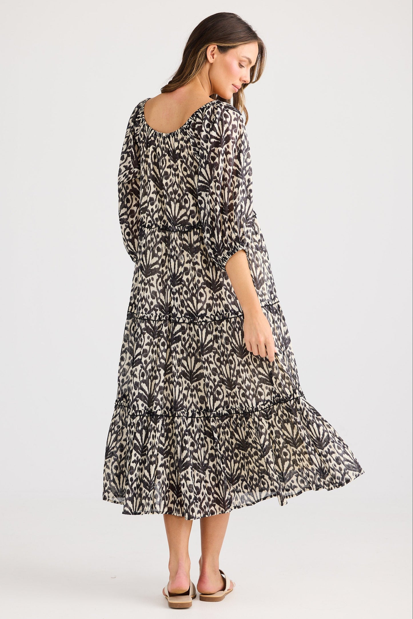 Woman wearing a patterned dress on a white background