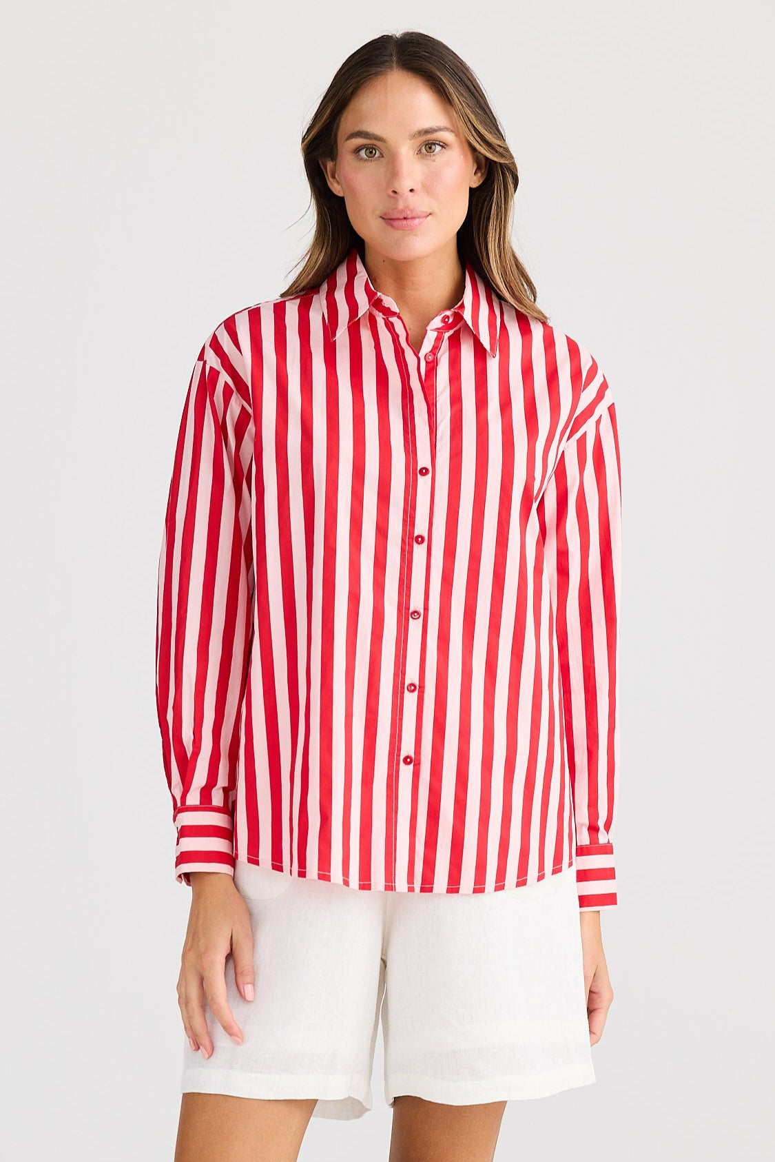 Woman wearing a red and white striped shirt and white shorts on a white background
