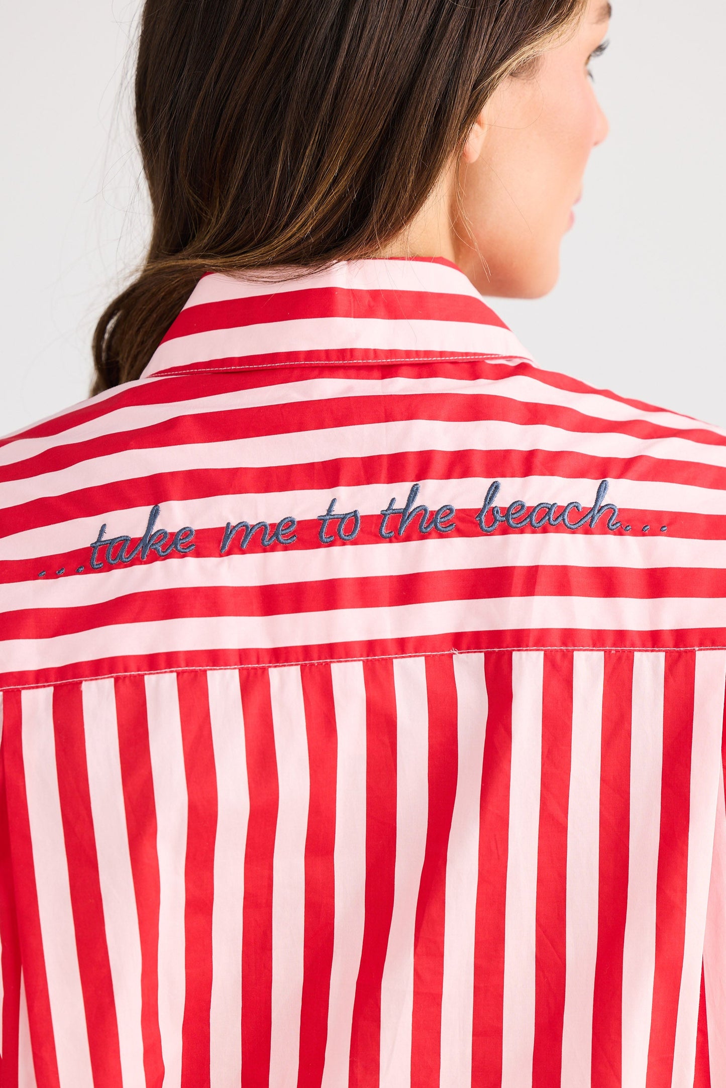 Red and white striped shirt with 'take me to the beach' text on a plain background