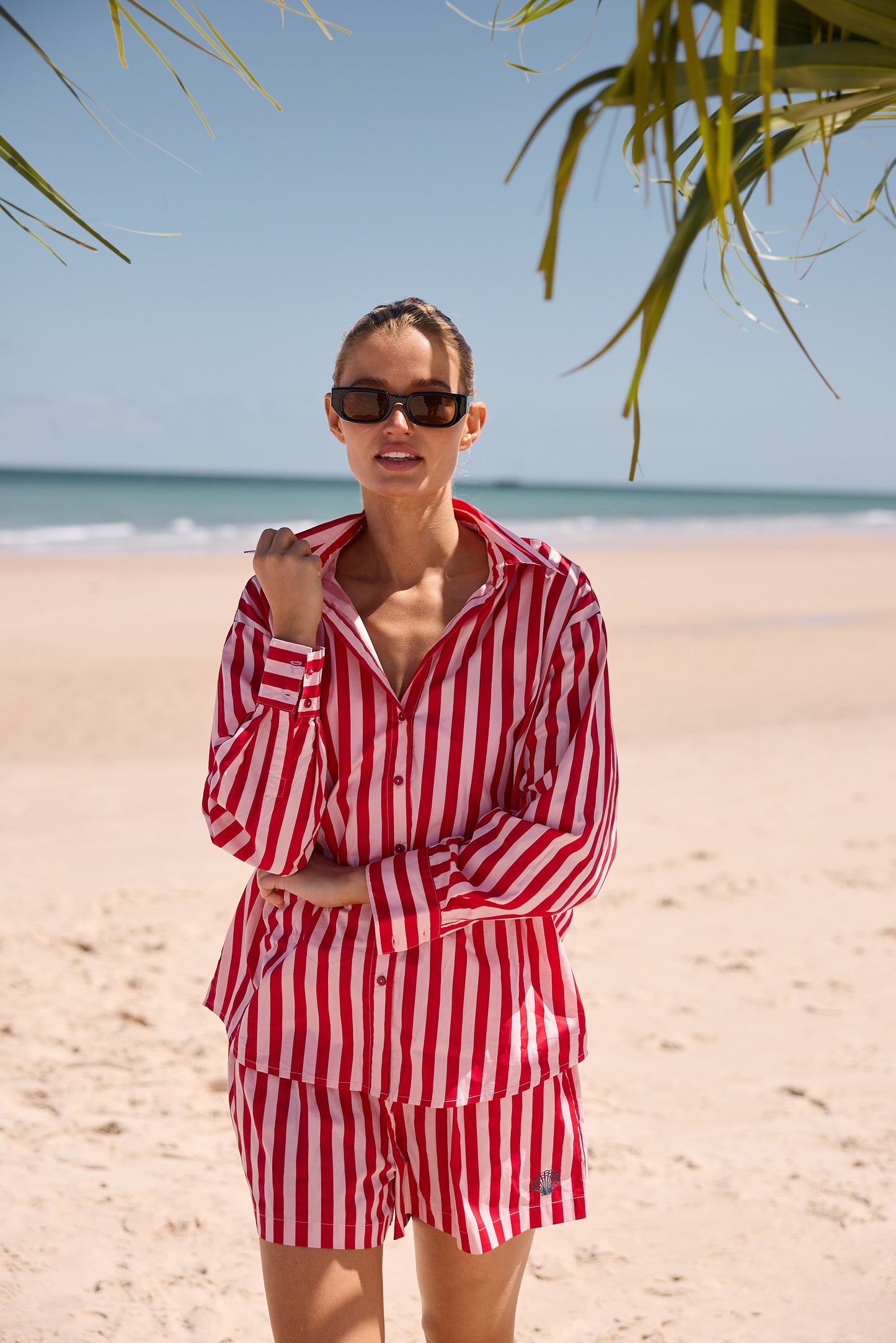 Woman in red and white striped outfit on a beach