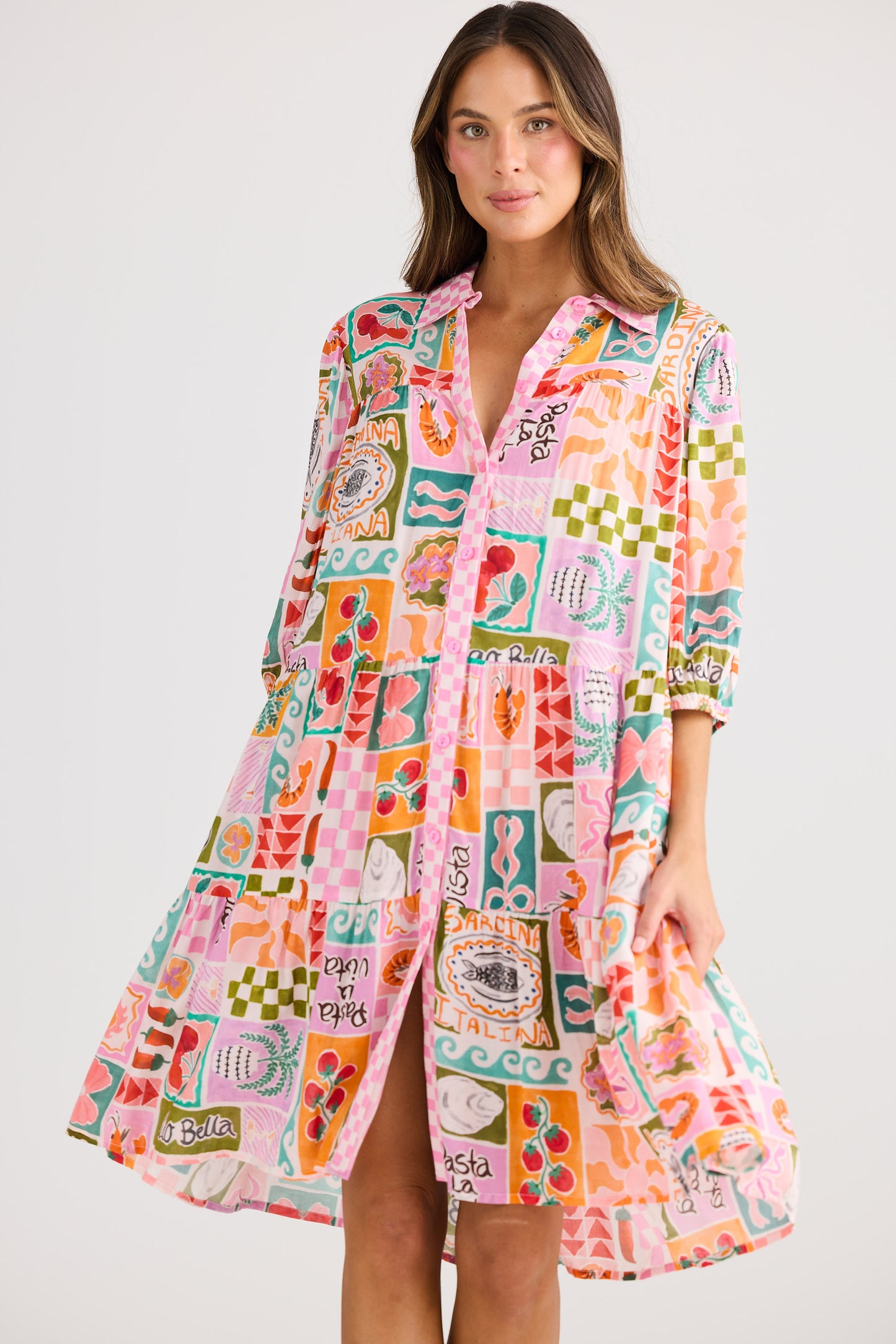 Woman wearing a colorful patterned dress on a plain background