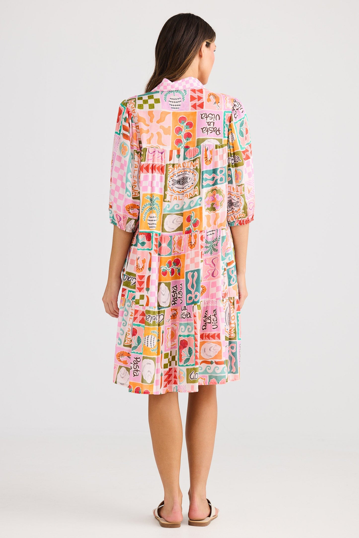 Woman wearing a colorful patterned dress on a white background