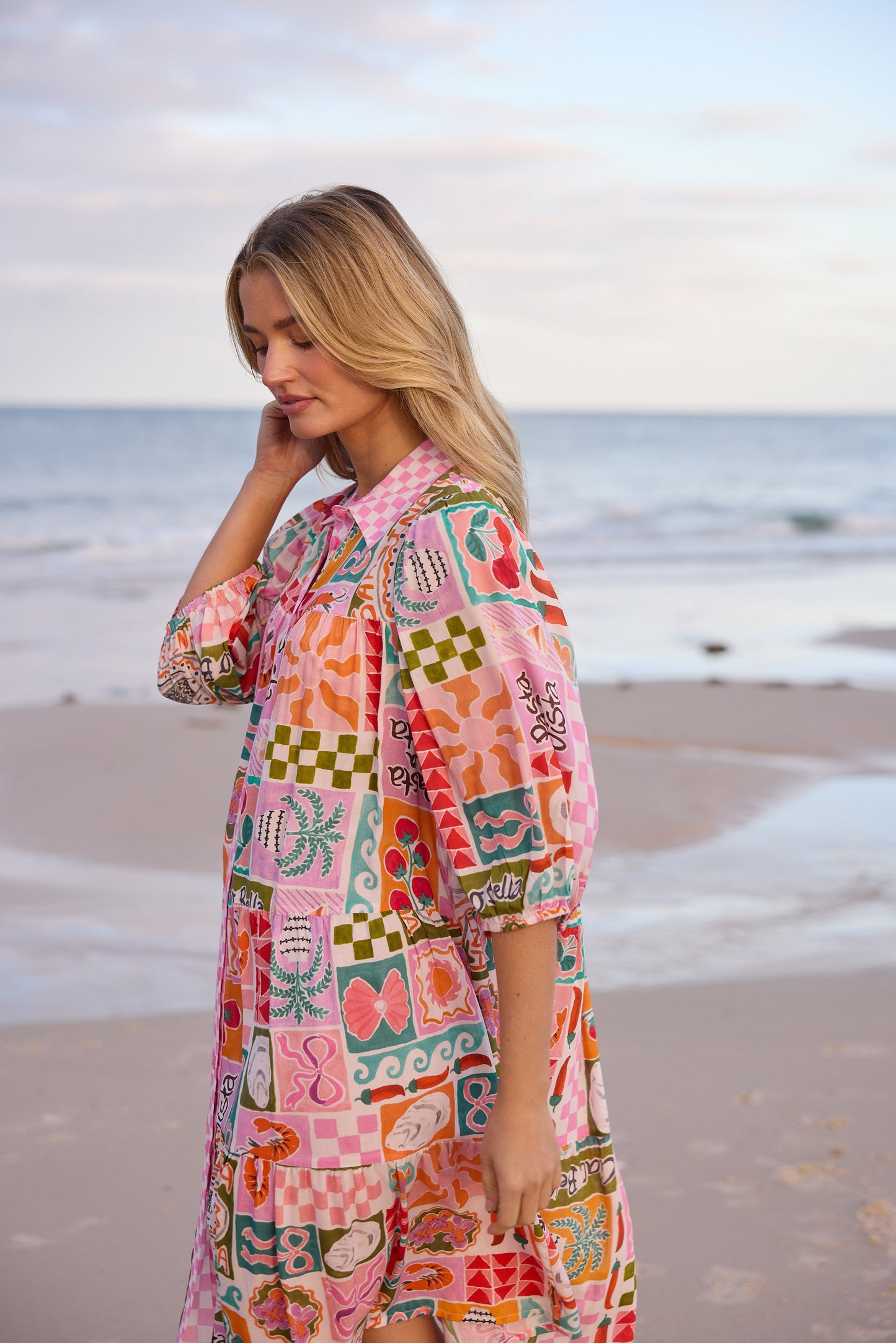 Woman wearing a colorful patterned dress on a beach