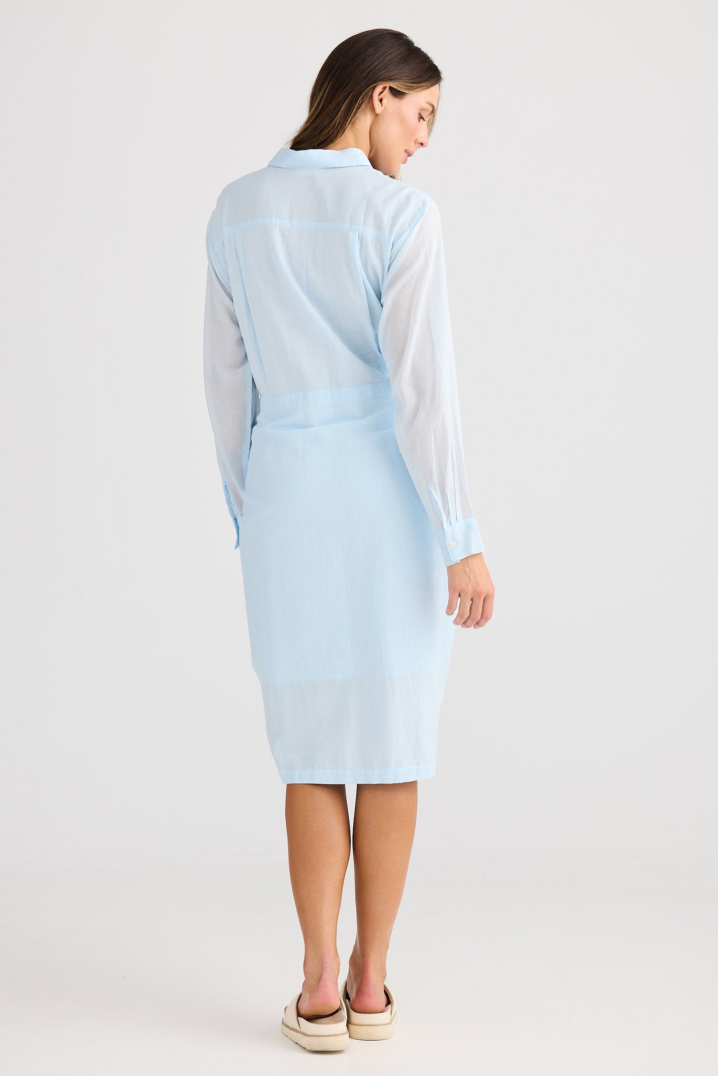Woman wearing a light blue dress with a white background