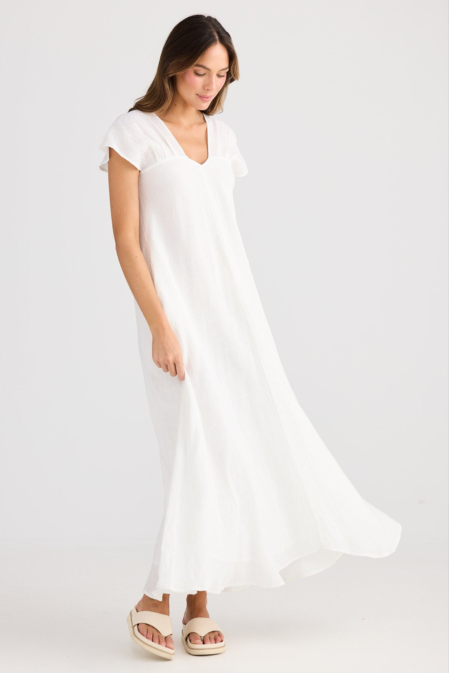 Woman wearing a white dress on a plain background