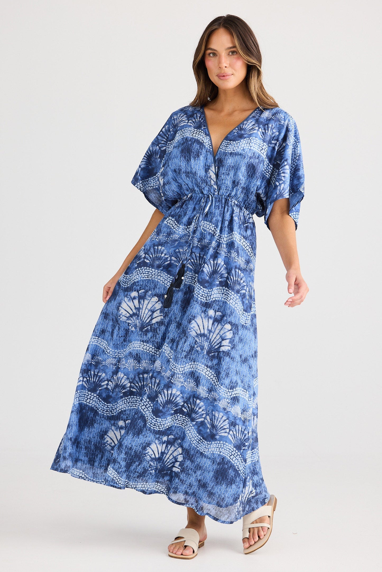 Woman wearing a blue patterned dress on a white background