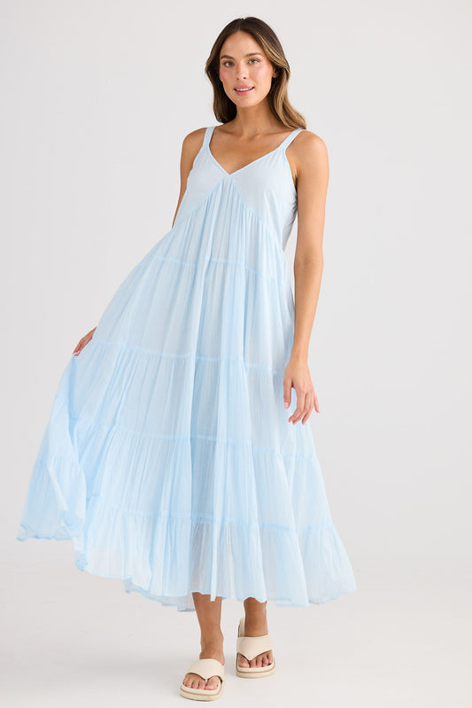 Woman wearing a light blue dress against a white background