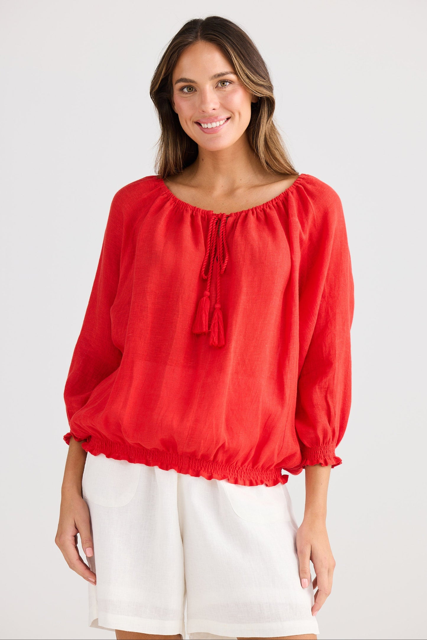 Woman wearing a red blouse with balloon sleeves on a white background