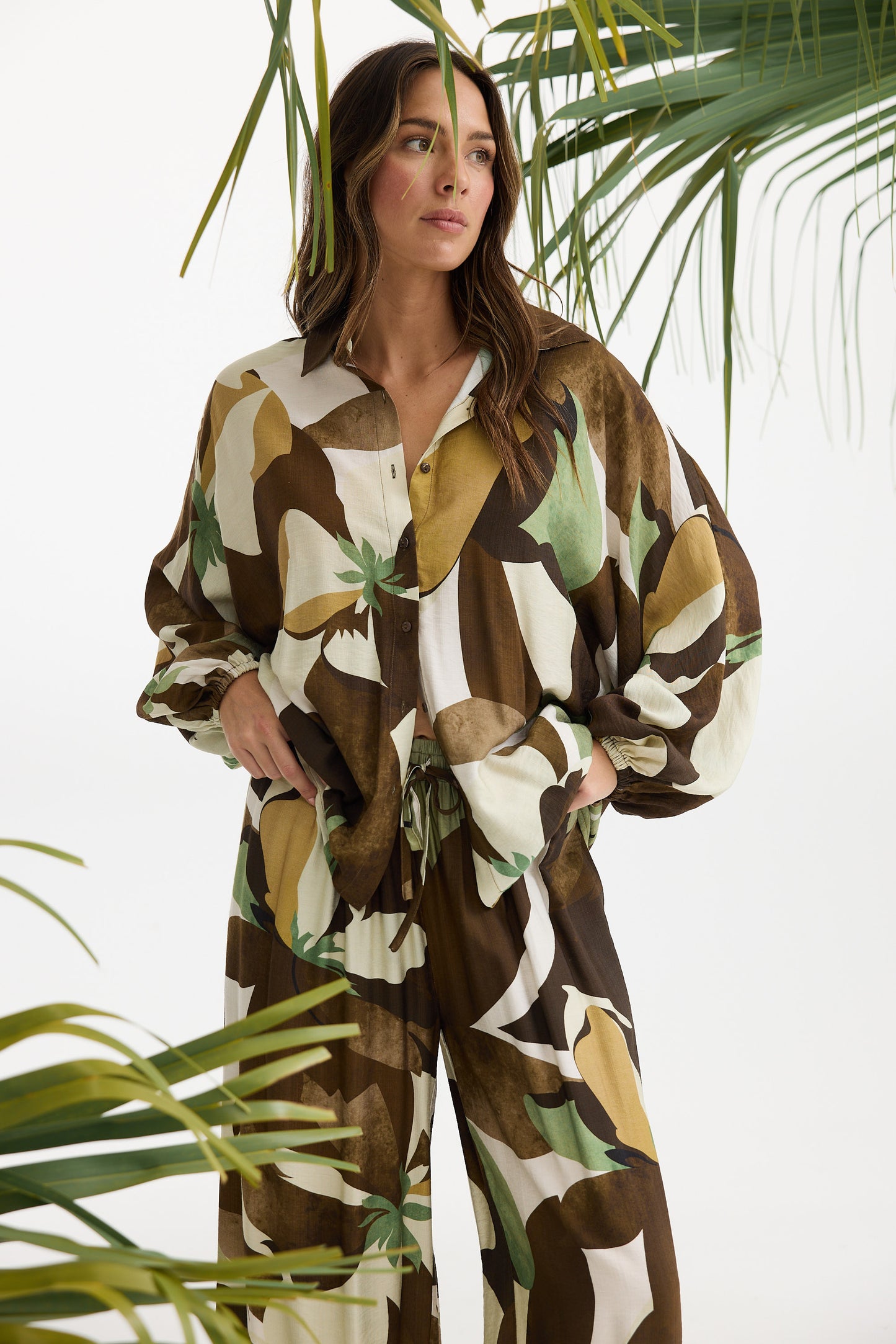 Woman wearing a patterned outfit with plants in the background