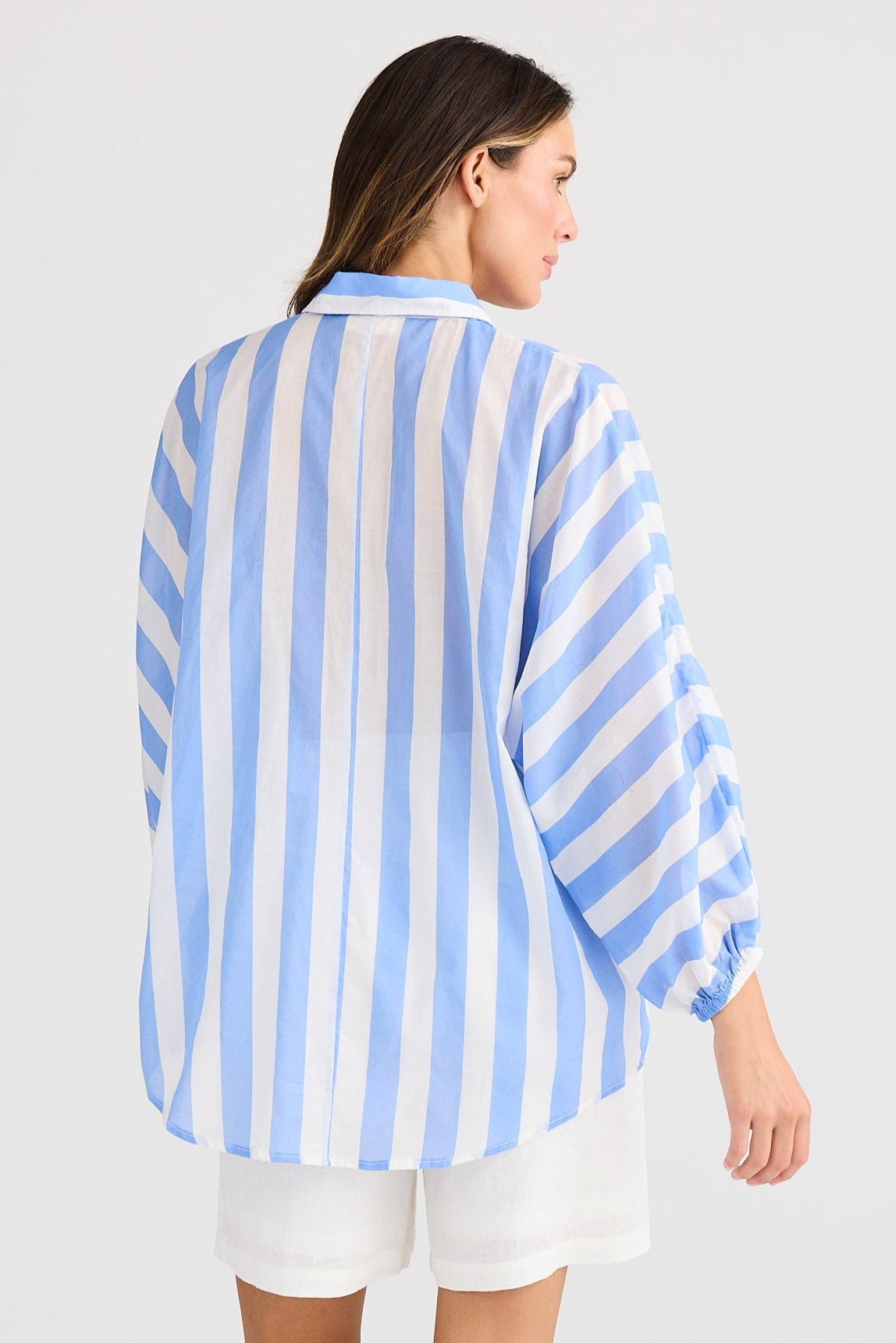 Woman wearing a blue and white striped shirt on a white background