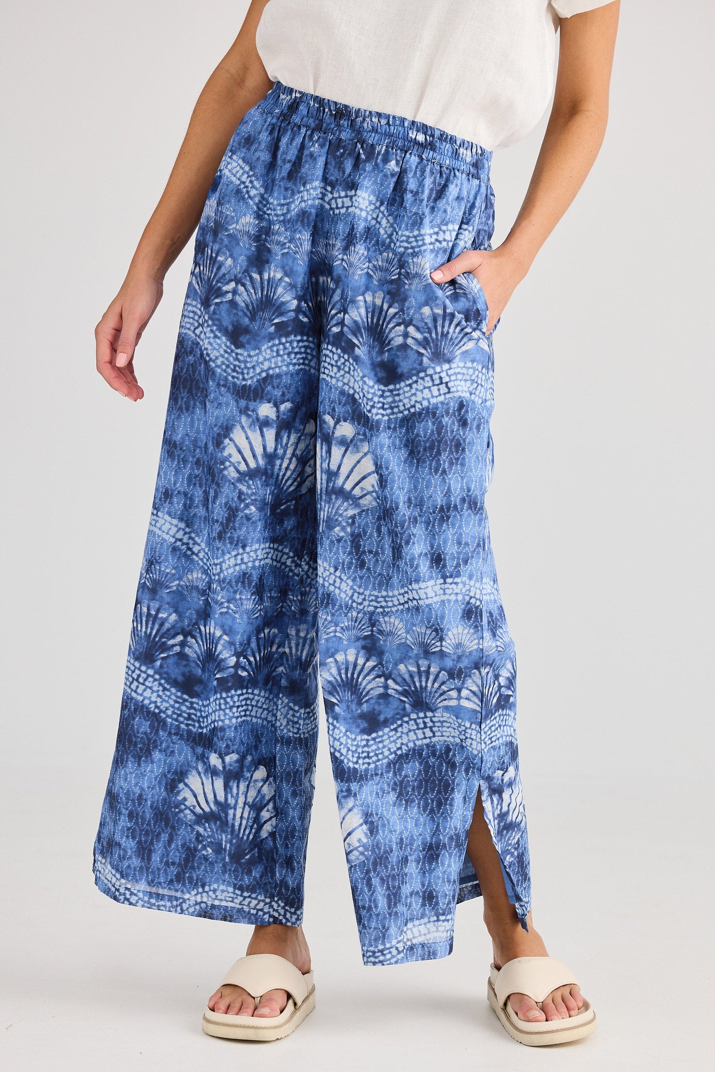Woman wearing blue patterned pants on a white background