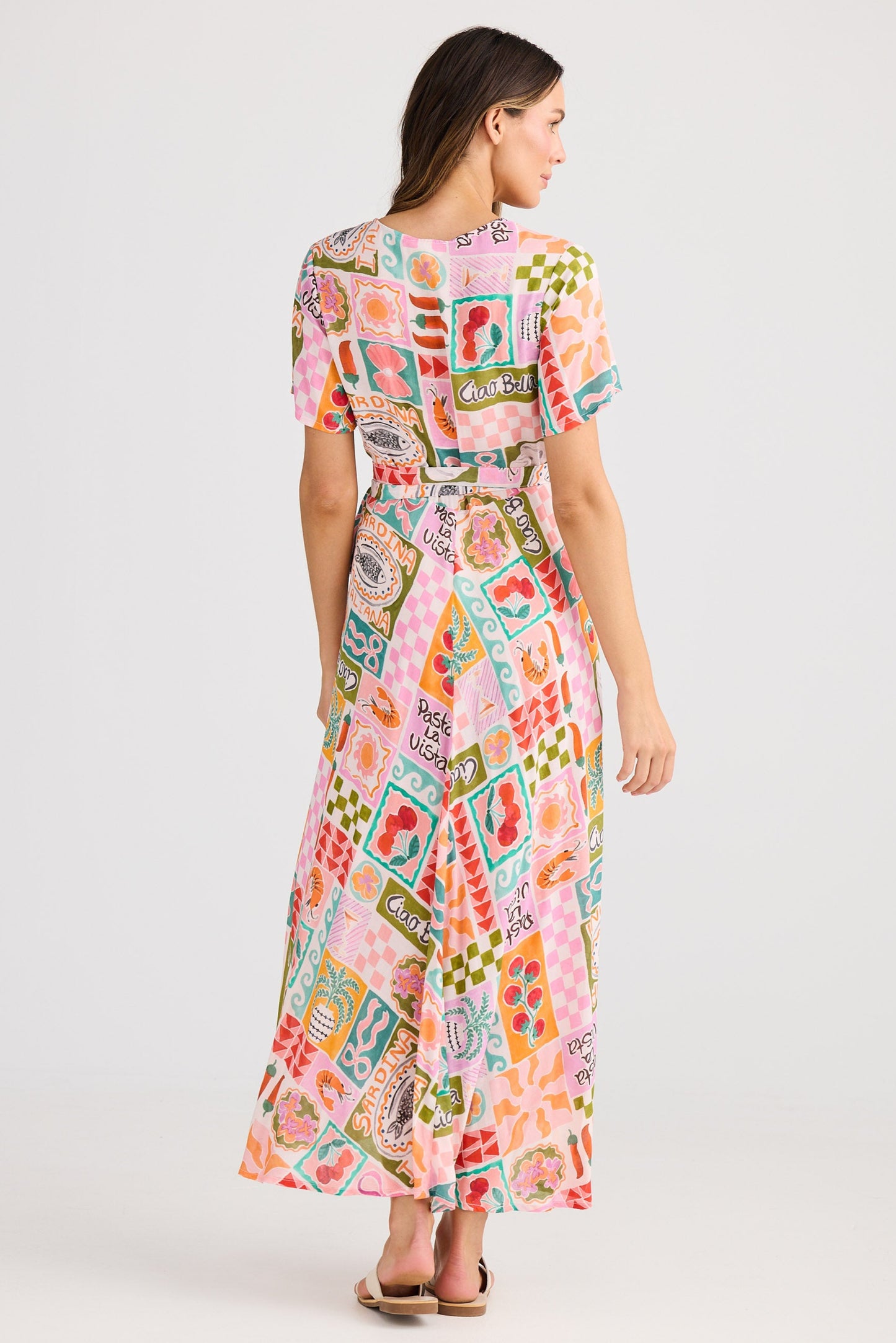 Woman wearing a colorful patterned dress on a white background