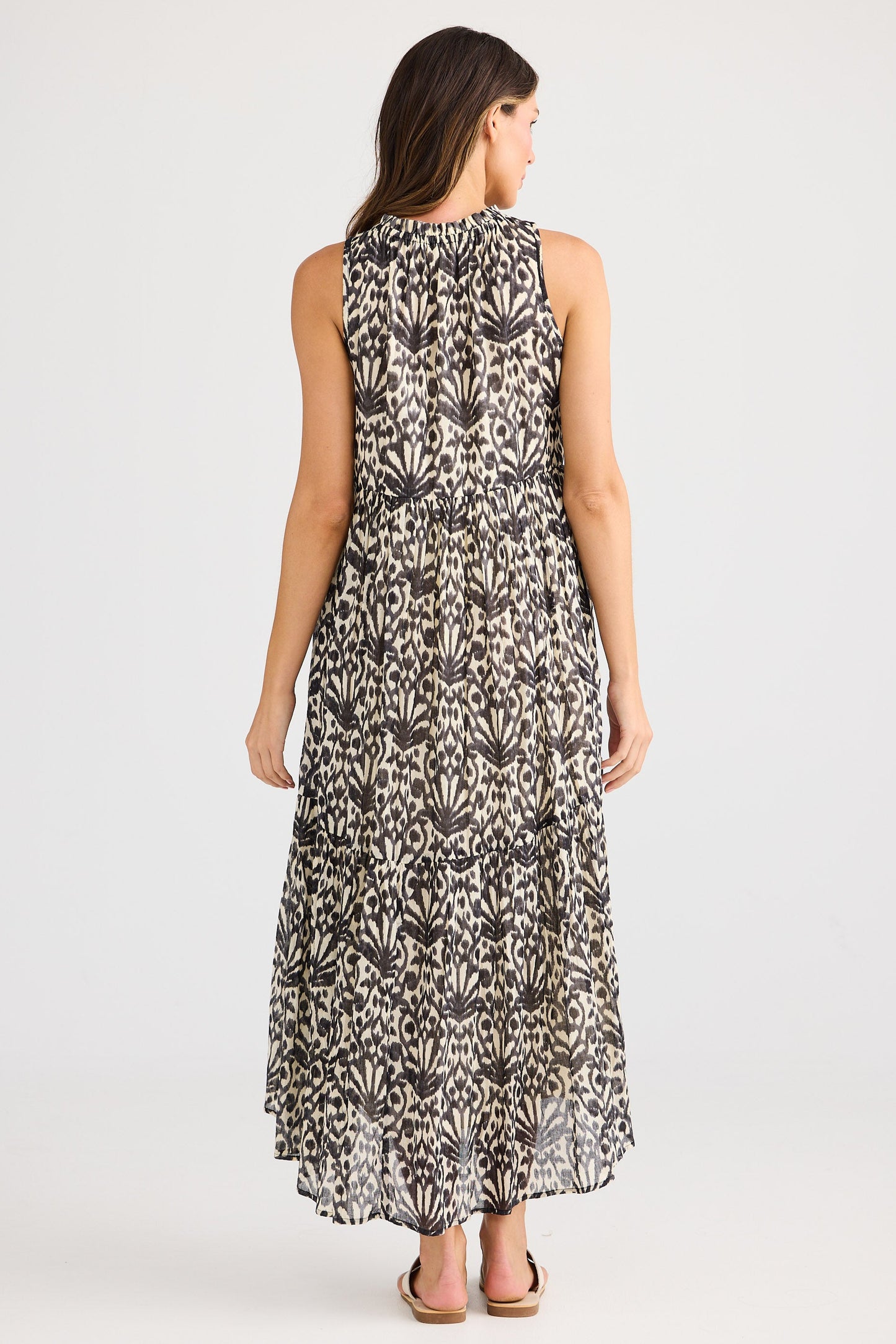 Woman wearing a sleeveless floral dress on a white background