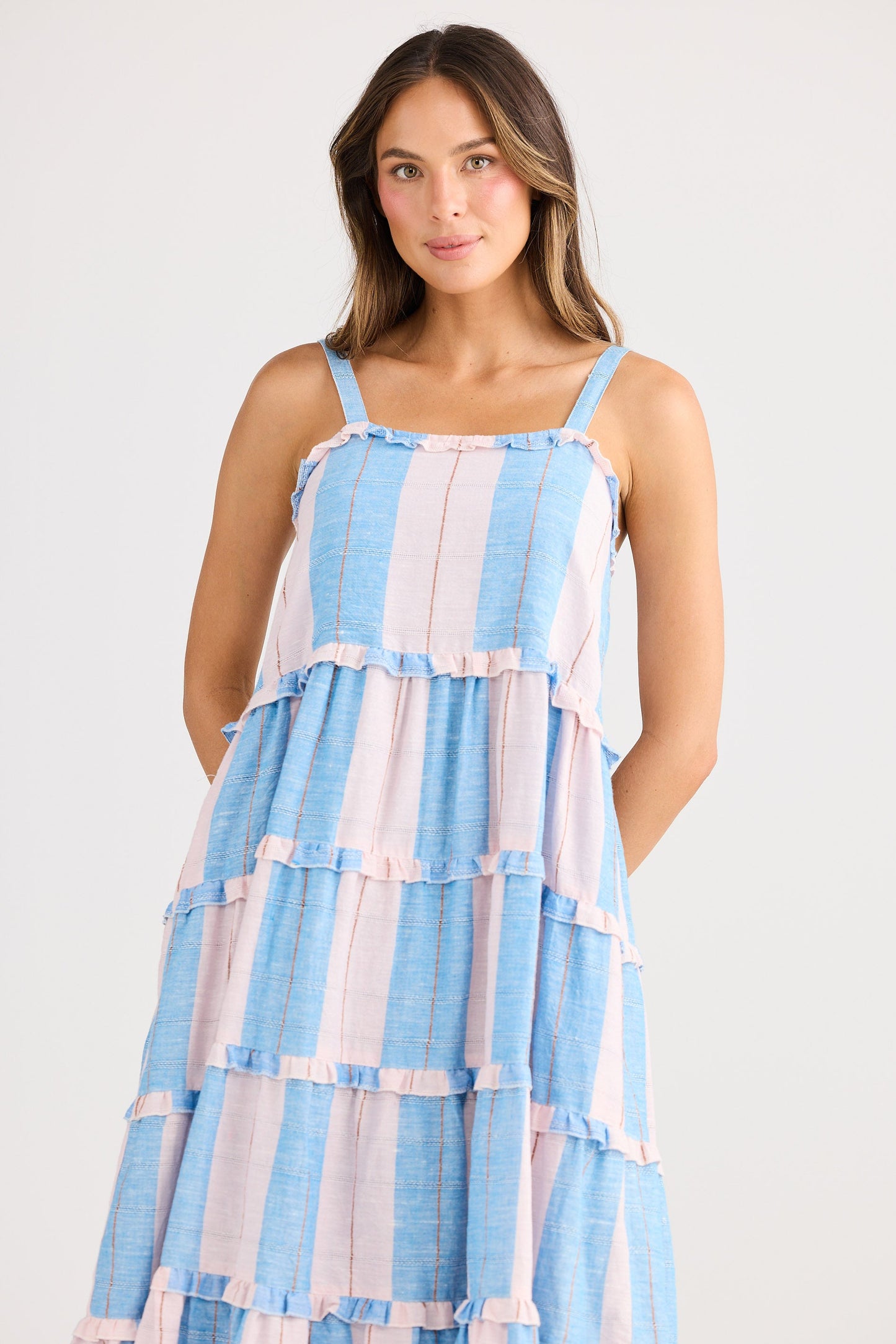 Woman wearing a blue and white striped dress on a white background