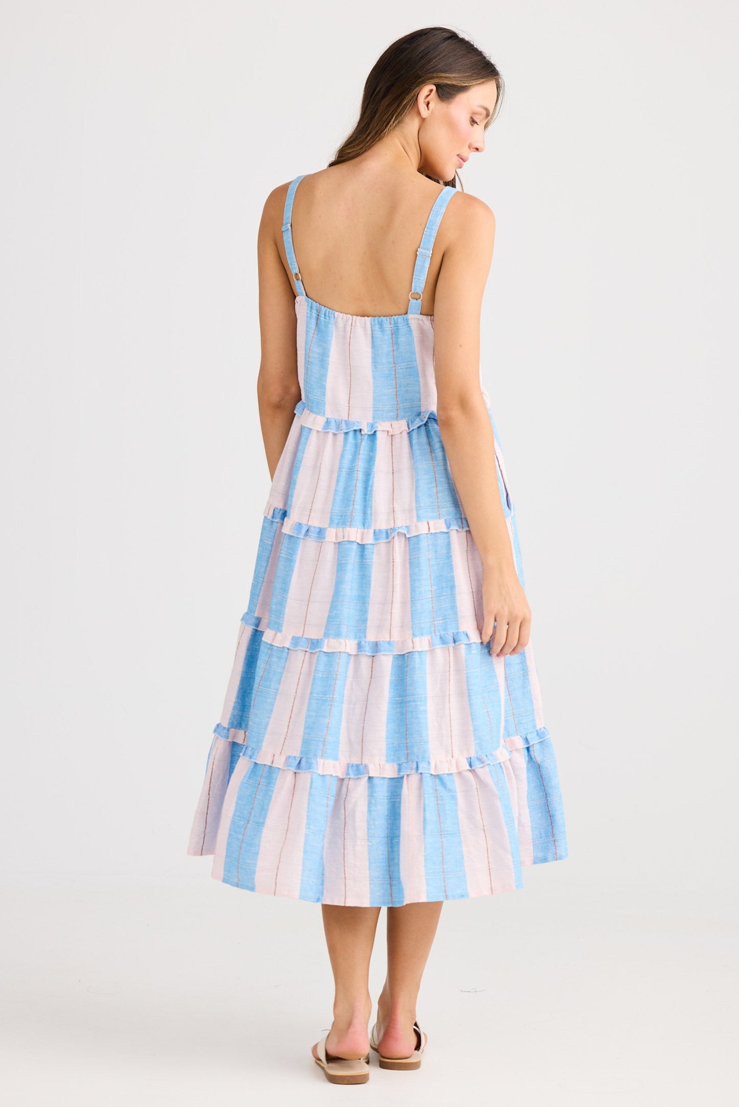 Woman wearing a blue and white striped dress on a white background