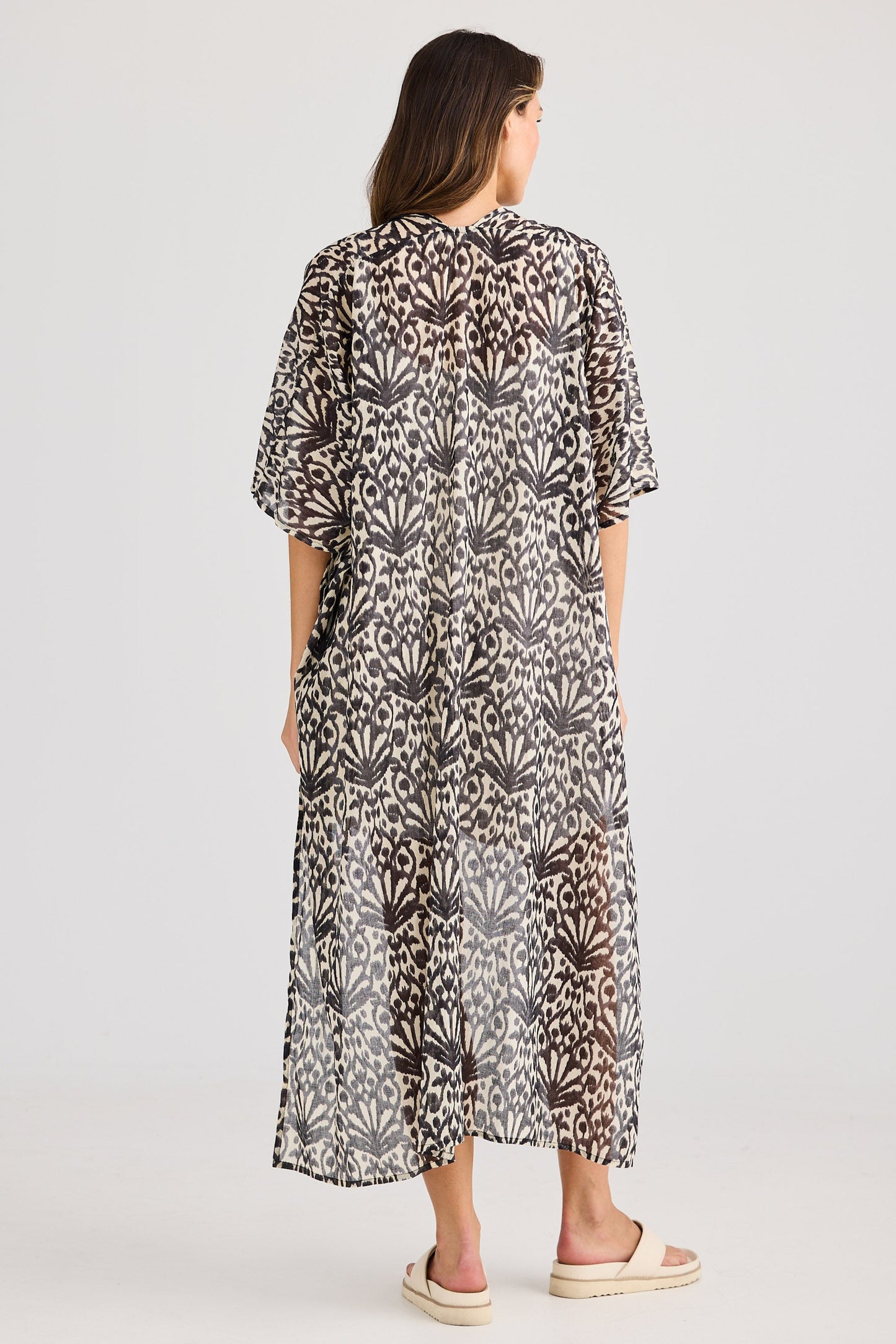 Woman wearing a patterned dress on a white background