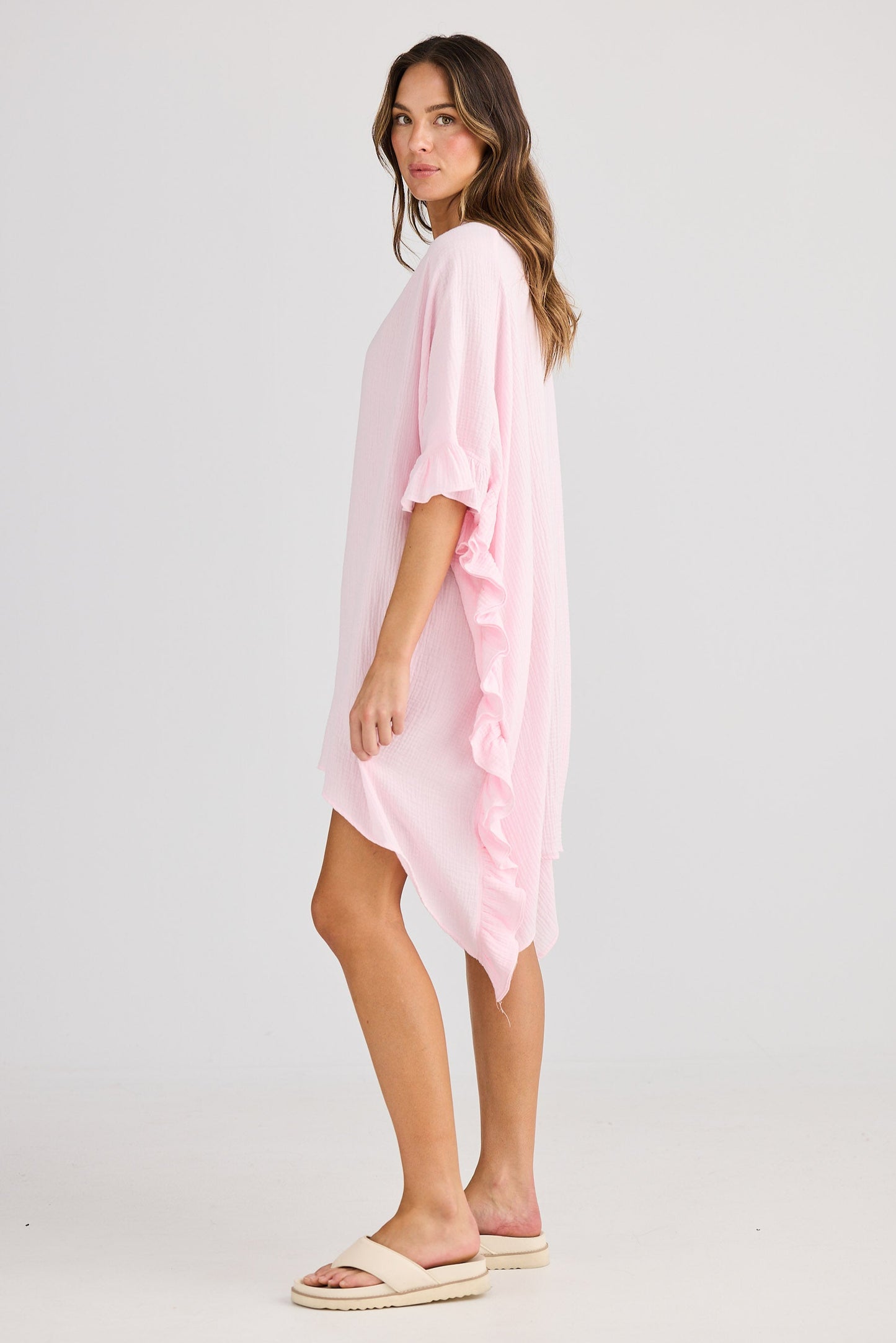 Woman wearing a light pink dress on a white background