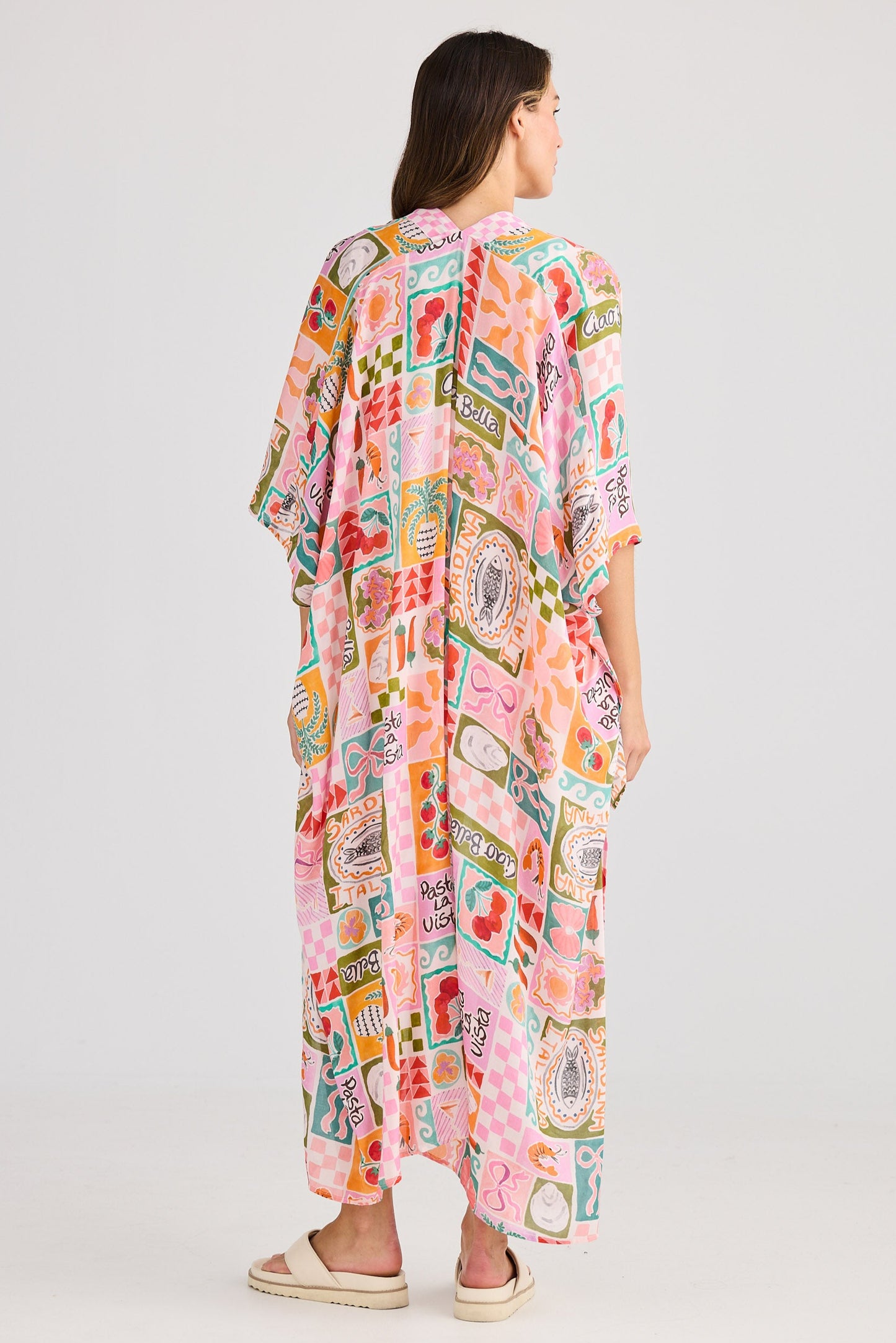 Woman wearing a colorful patterned dress on a white background