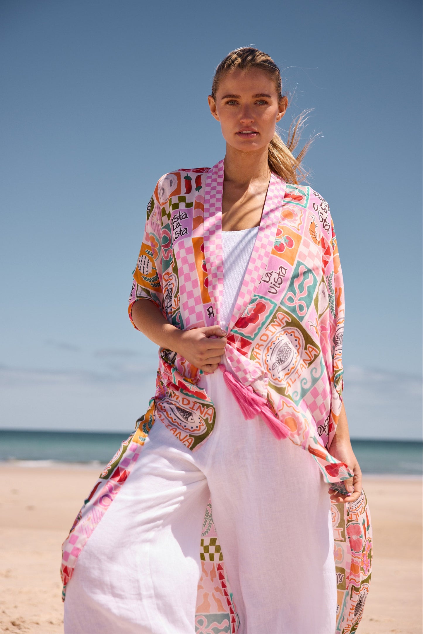 Woman wearing a colorful kimono-style garment on a beach