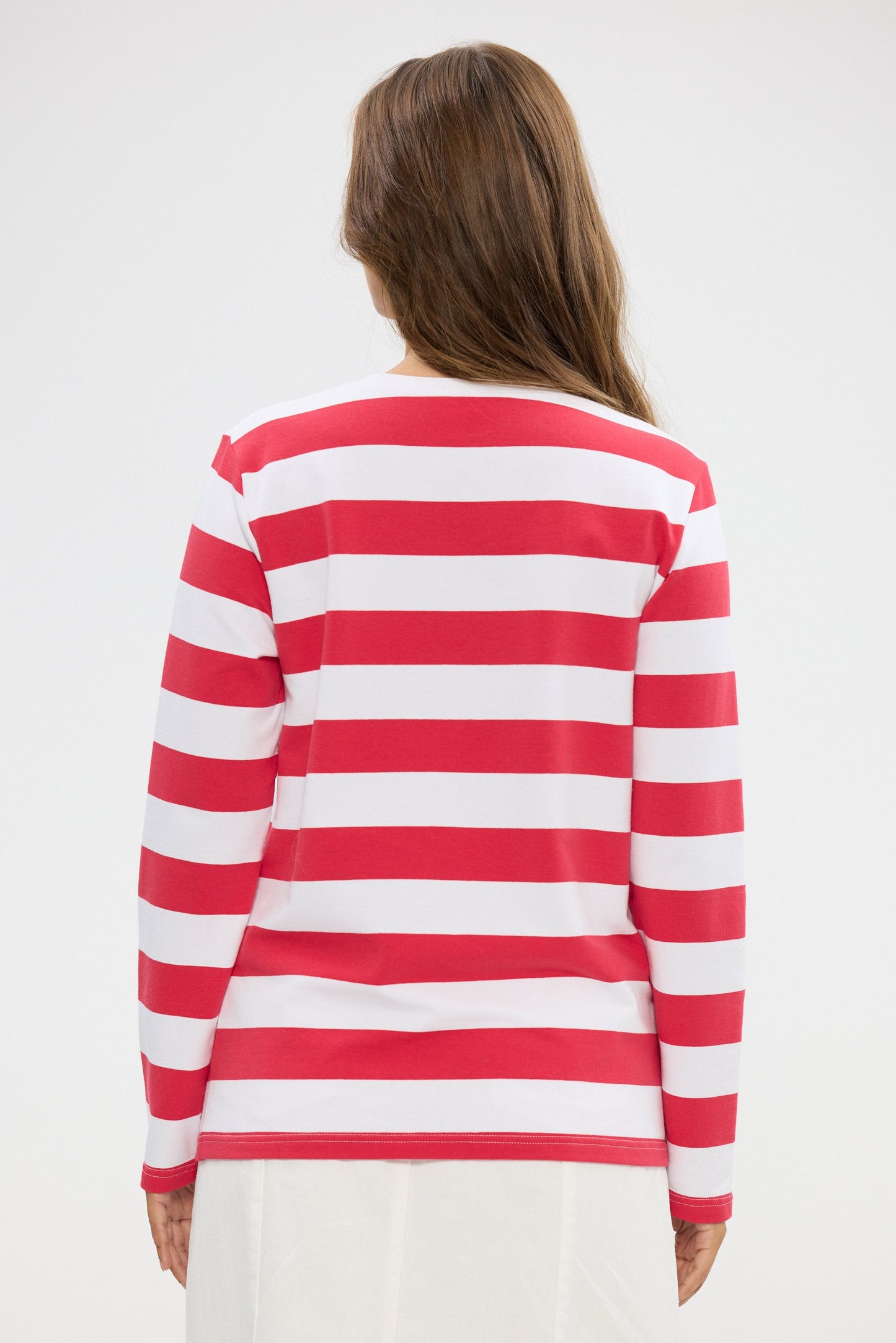 Person wearing a red and white striped top on a plain background