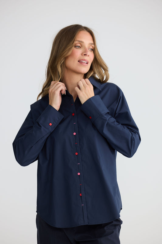Model wearing Fae Shirt Navy with contrast buttons and stitching, alternate view on white background