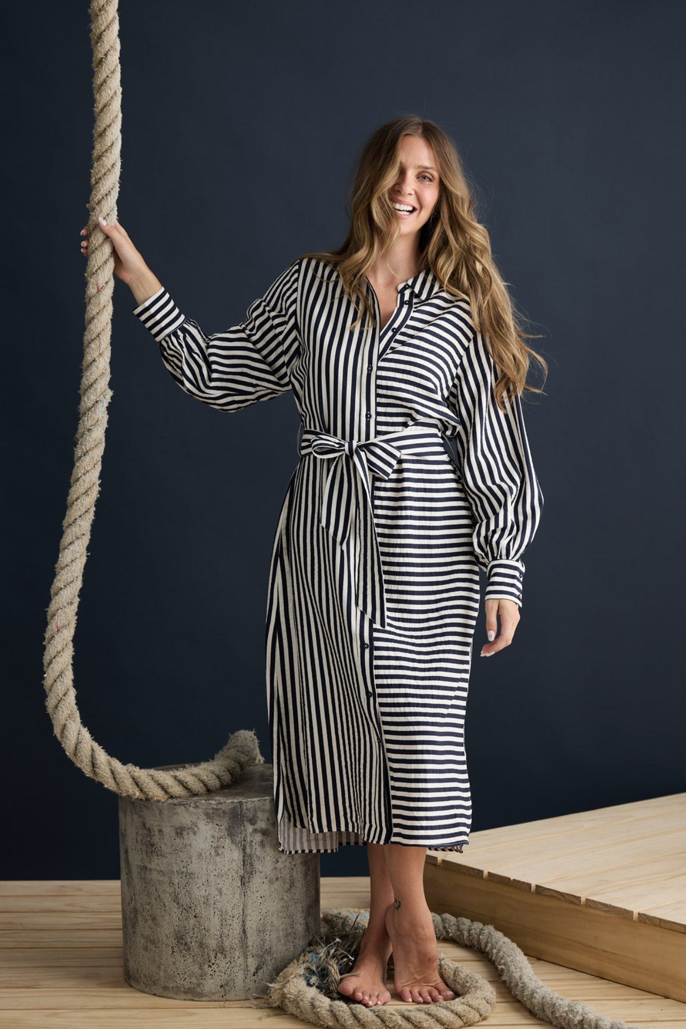 Model wearing Carnation Shirt Dress Navy and White Stripe with waist tie and in-seam pockets, campaign lifestyle view