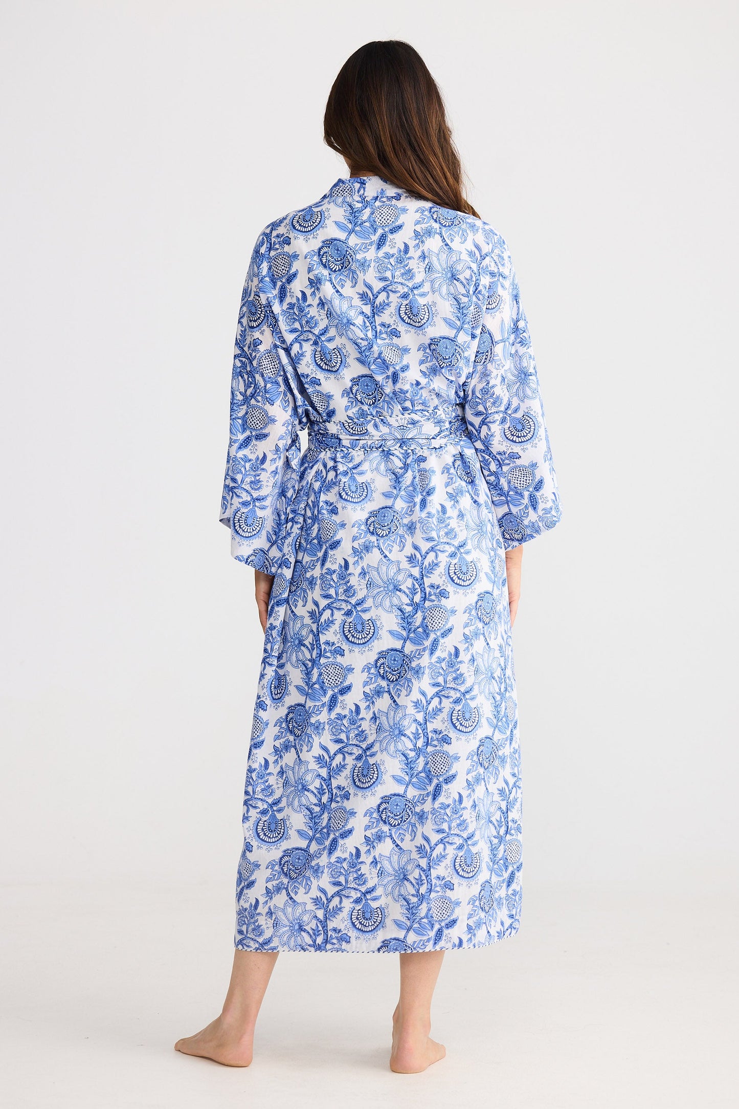 Woman wearing a blue floral robe on a white background