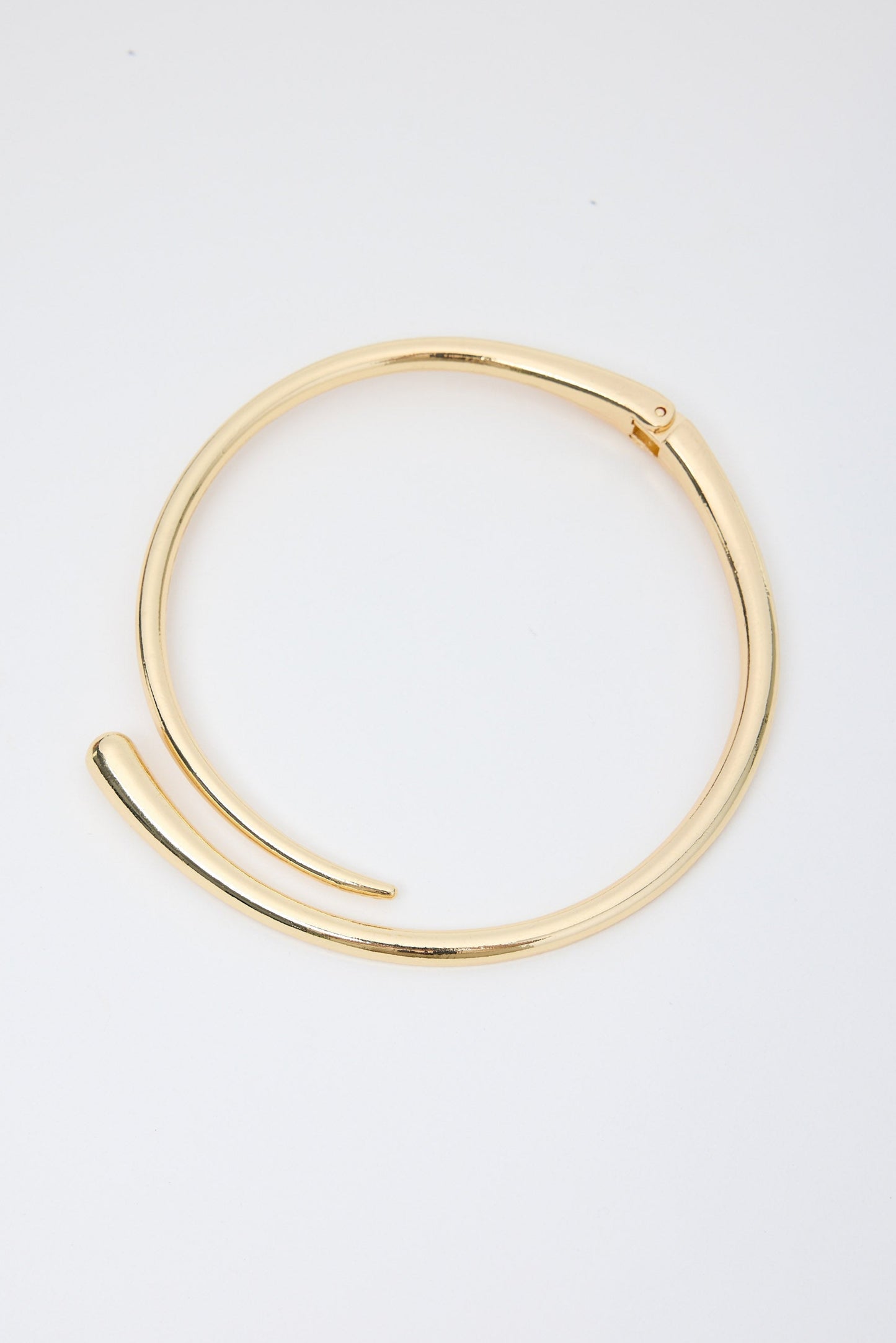 Gold necklace on a light gray background