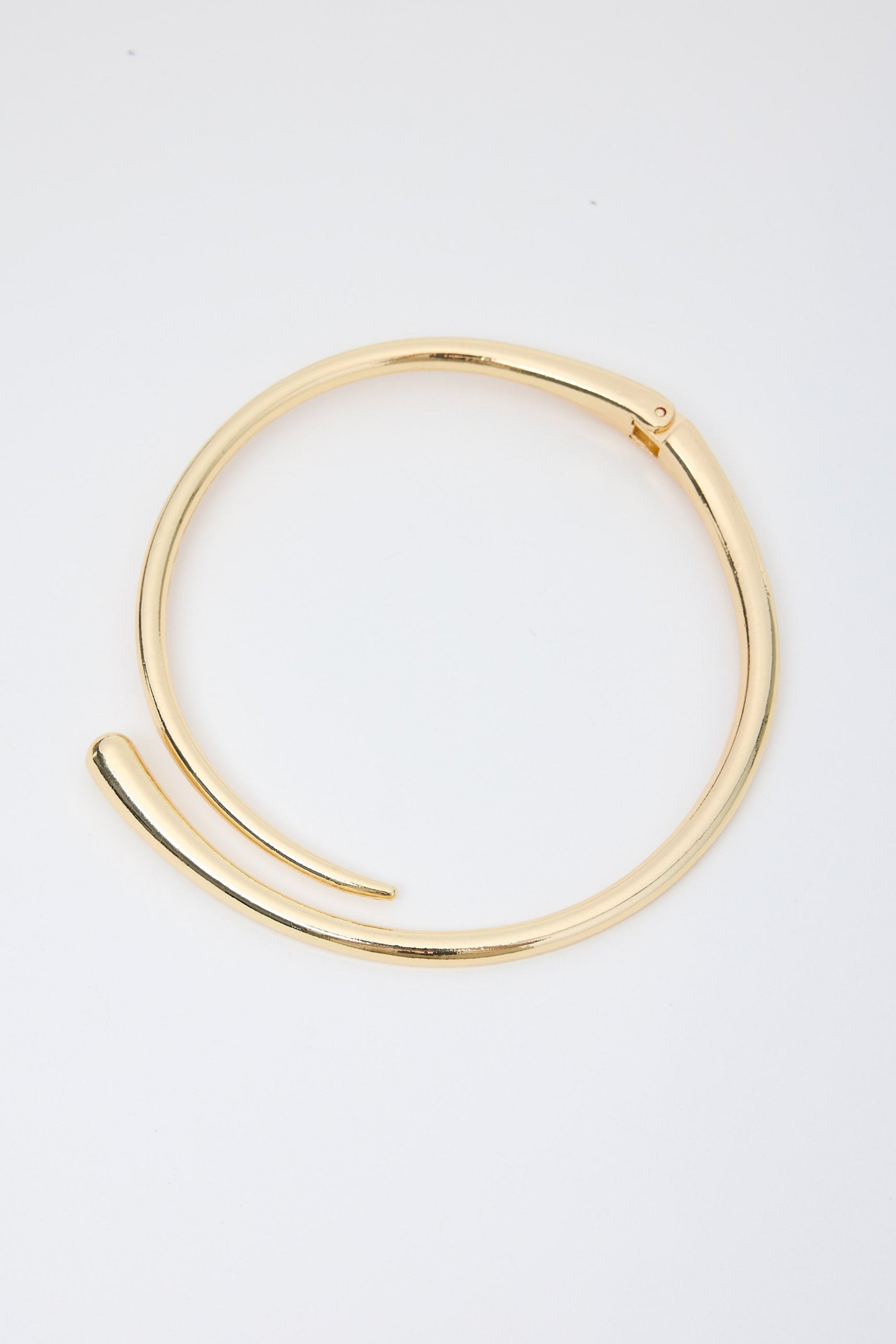 Gold necklace on a light gray background