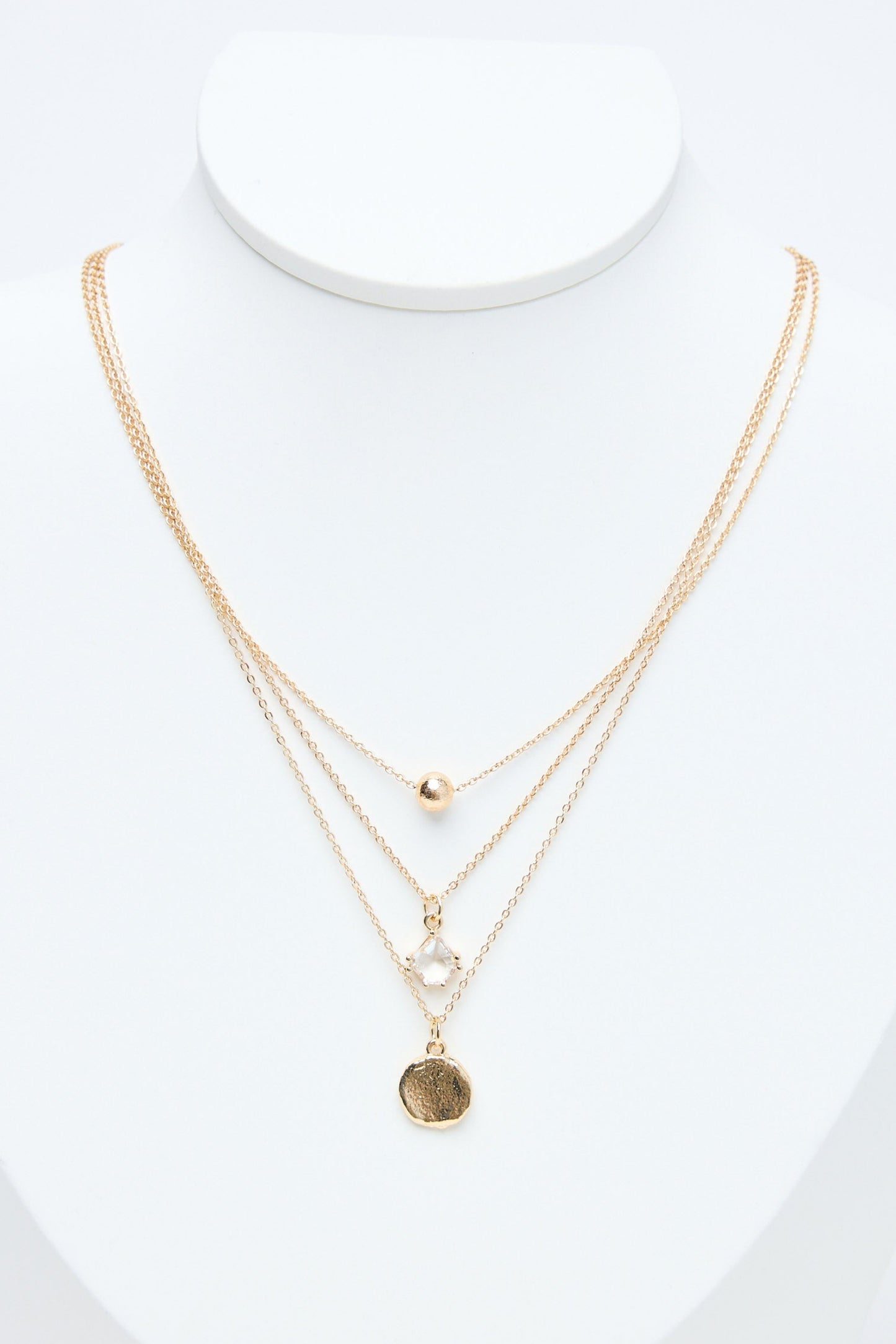 Gold necklaces on a mannequin with a white background