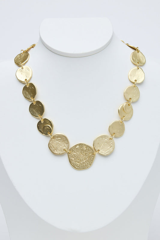 Gold necklace on a mannequin with a white background