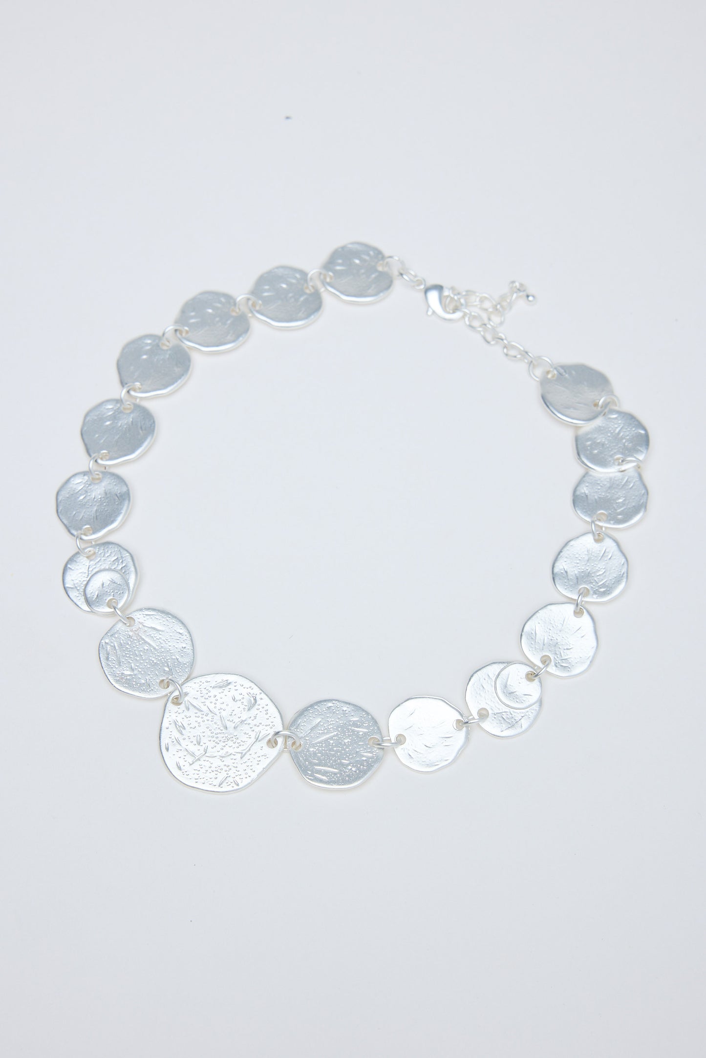 Necklace with gray and silver circular coins on a white background