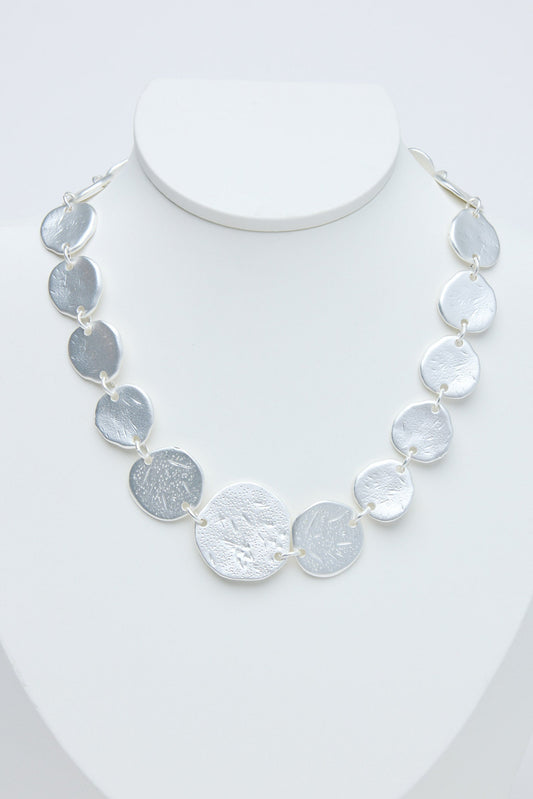 Necklace with gray and silver circular coins on a white background