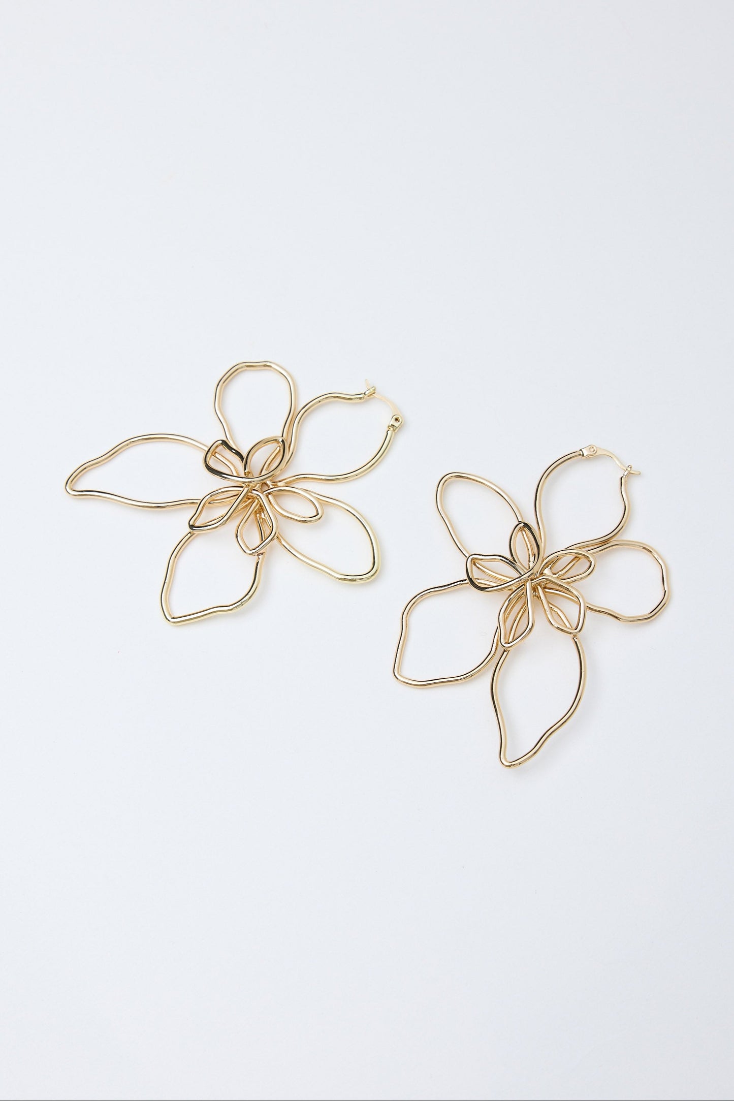 Pair of gold flower-shaped earrings on a white background