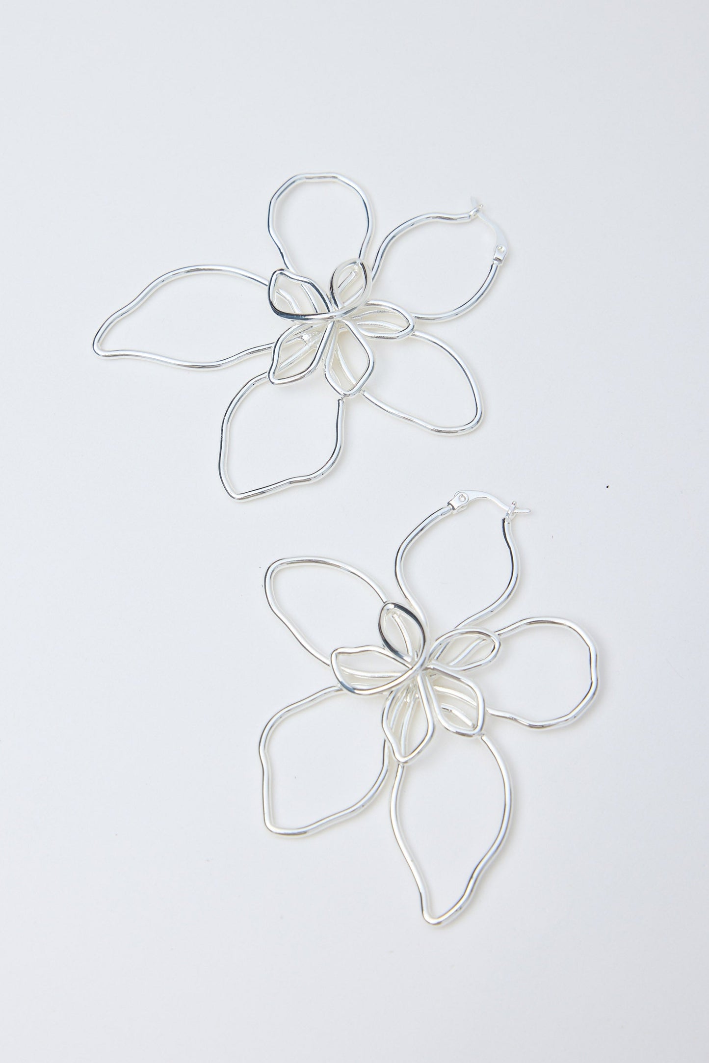 Silver flower-shaped earrings on a white background
