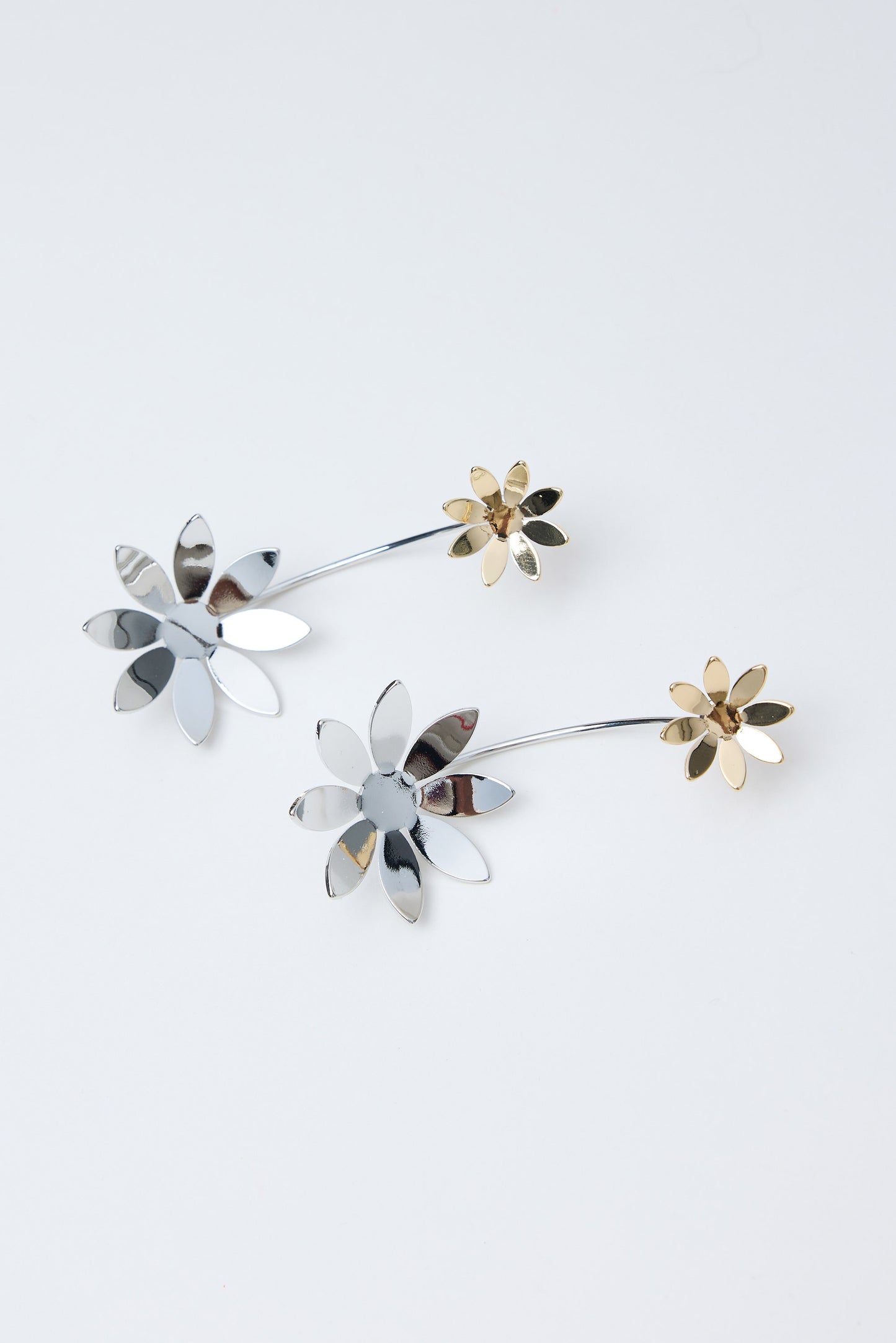 Floral-shaped earrings on a light gray background