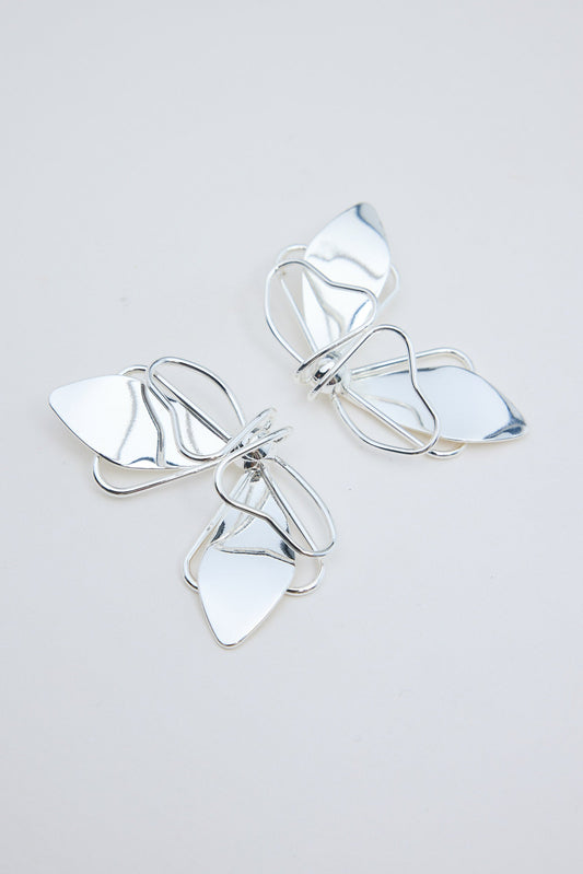Pair of silver butterfly-shaped earrings on a light gray background
