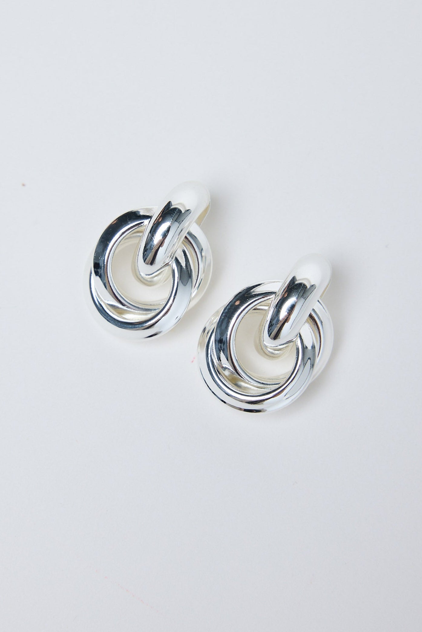 Pair of silver hoop earrings on a light gray background